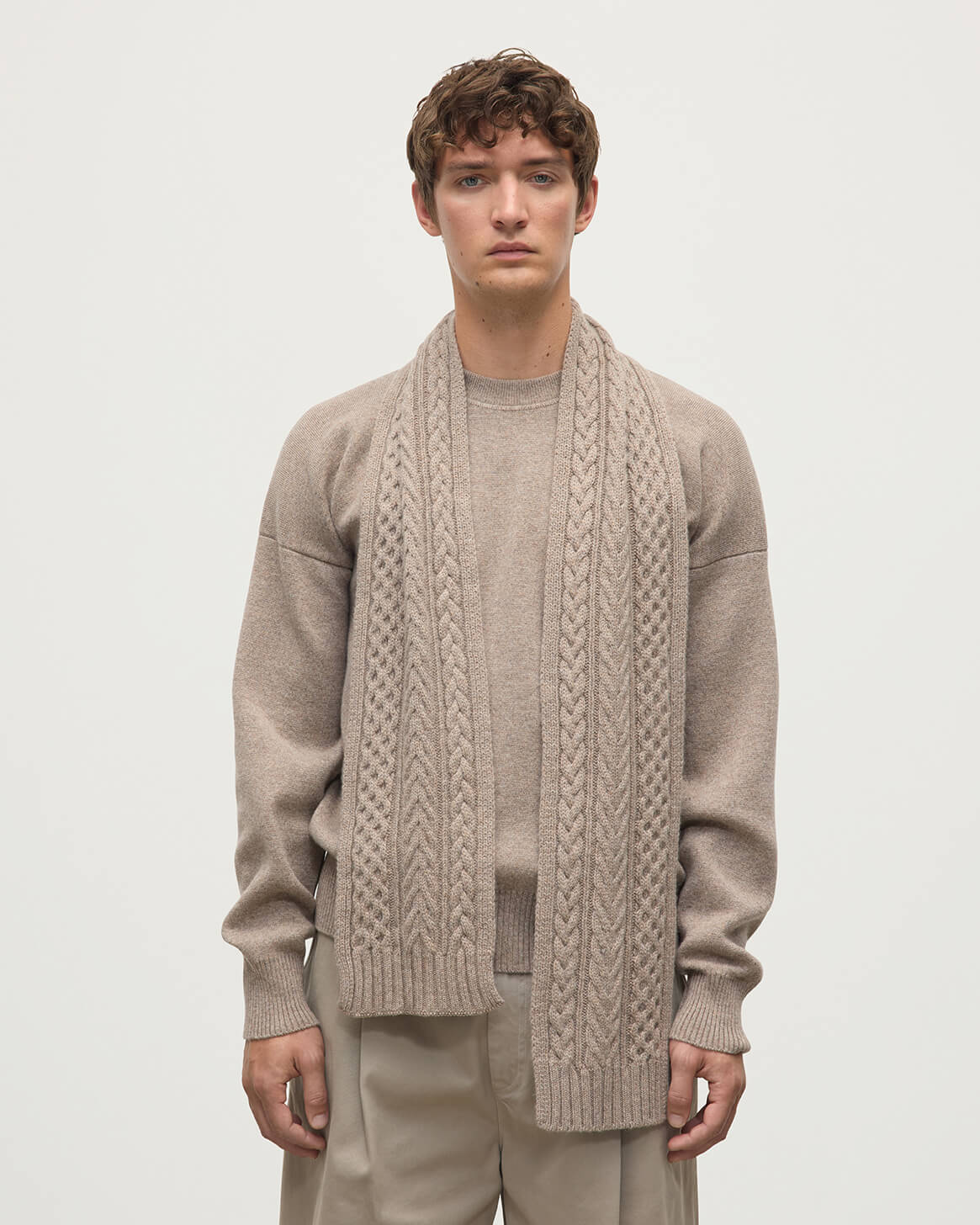 Model wears Johnstons of Elgin ash brown cable cashmere scarf HAC03406HB4334ONE