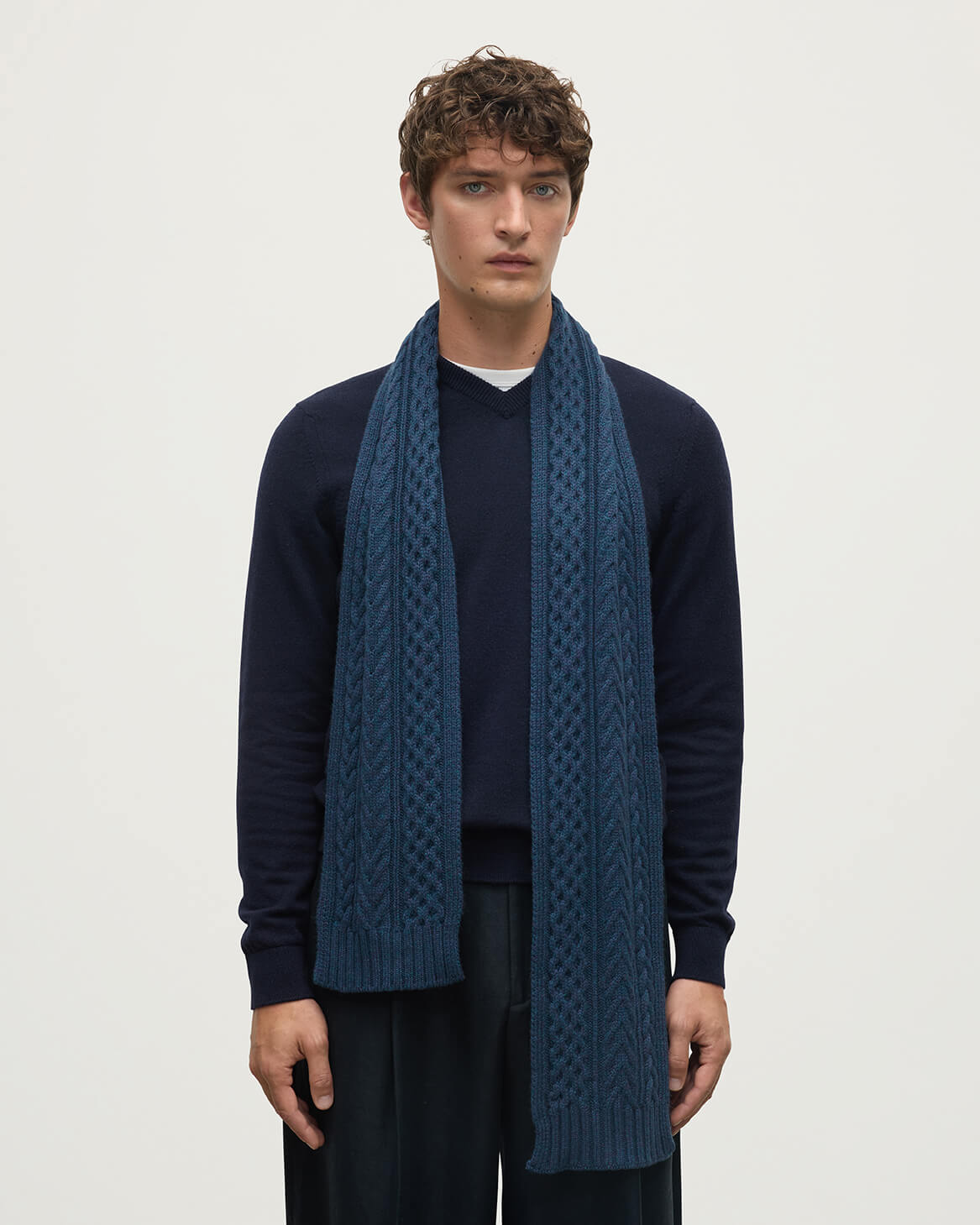 Model wears Johnstons of Elgin Heather Navy cable cashmere scarf HAC03406HD7321ONE