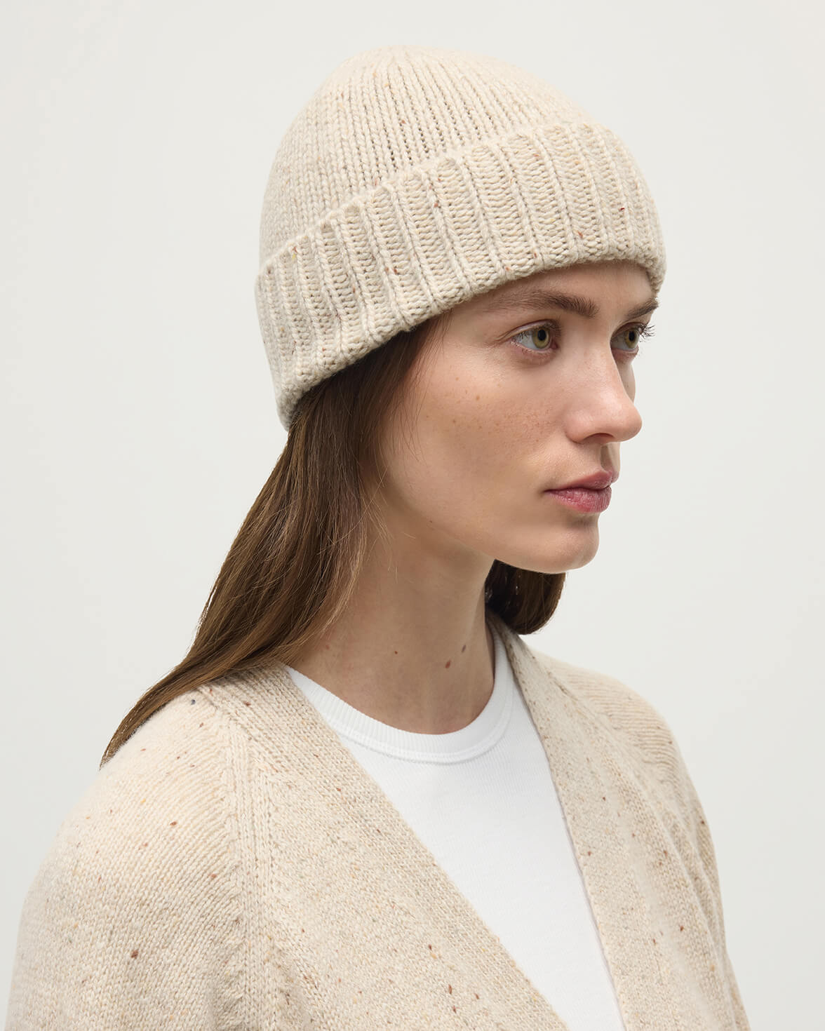 Model wears Johnstons of Elgin AW25 Knitted Accessories Cream Dun Donegal Cashmere Cream Beanie HAC03525006334ONE