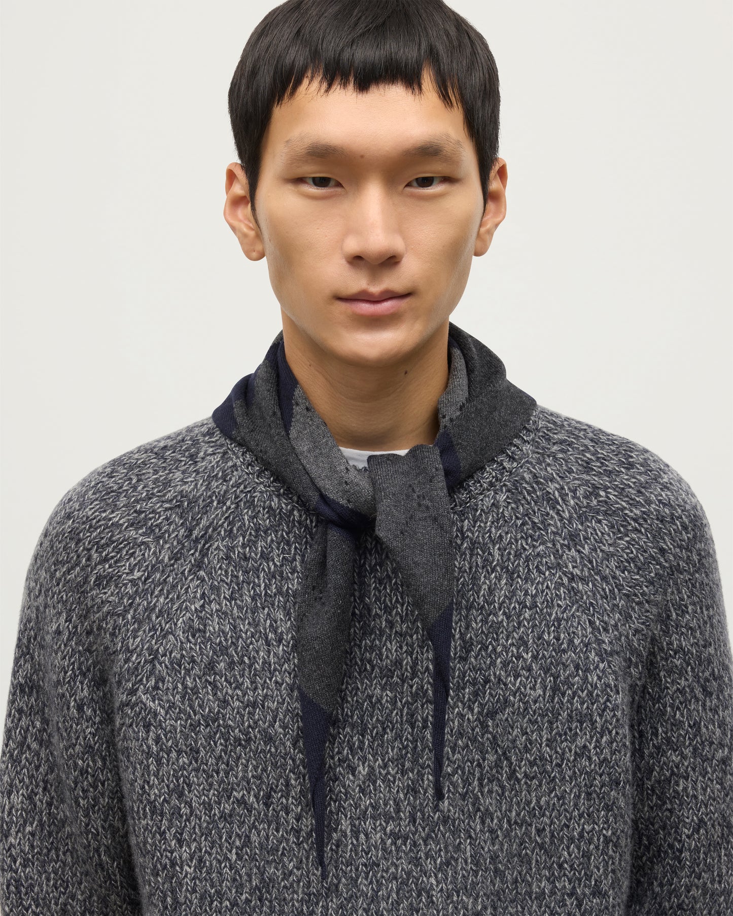 JOHNSTONS OF ELGIN CLAN BANDANA NAVY 100% CASHMERE ON A MALE MODEL OVER A NAVY MARL CASHMERE SWEATER HAP03612JU1613ONE