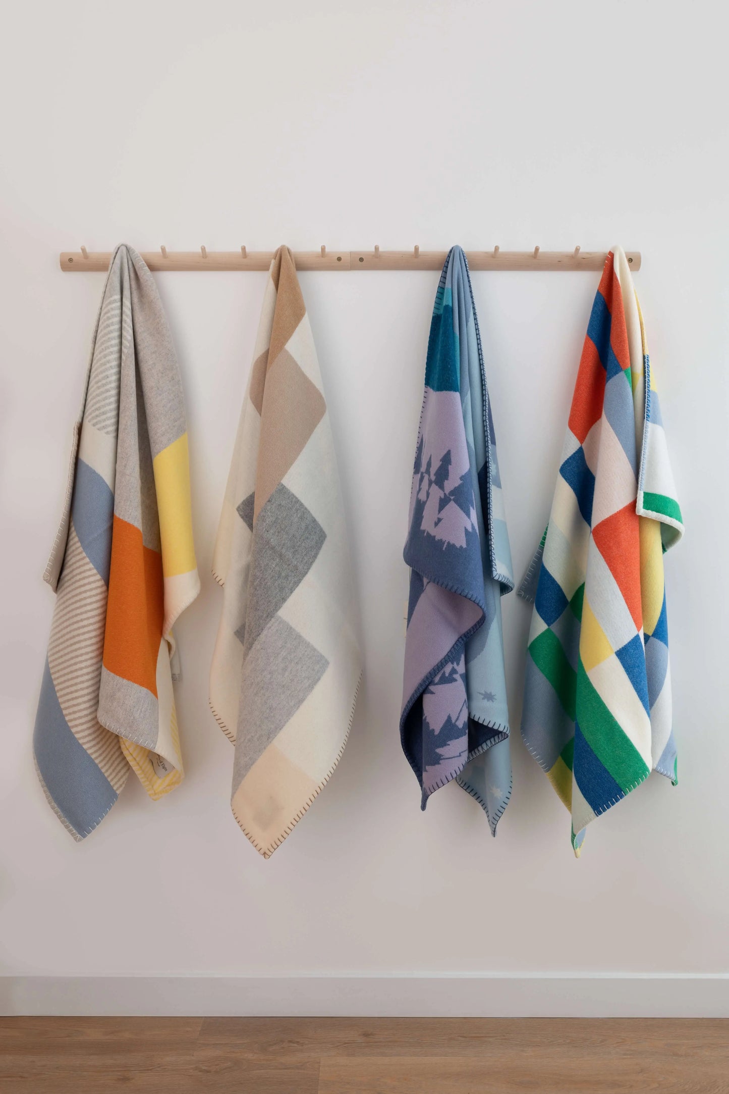 2025 Johnstons of Elgin Interiors Collection Children's Blanket Collection hanging on wooden pages on a white background TB000582RU7440ONE