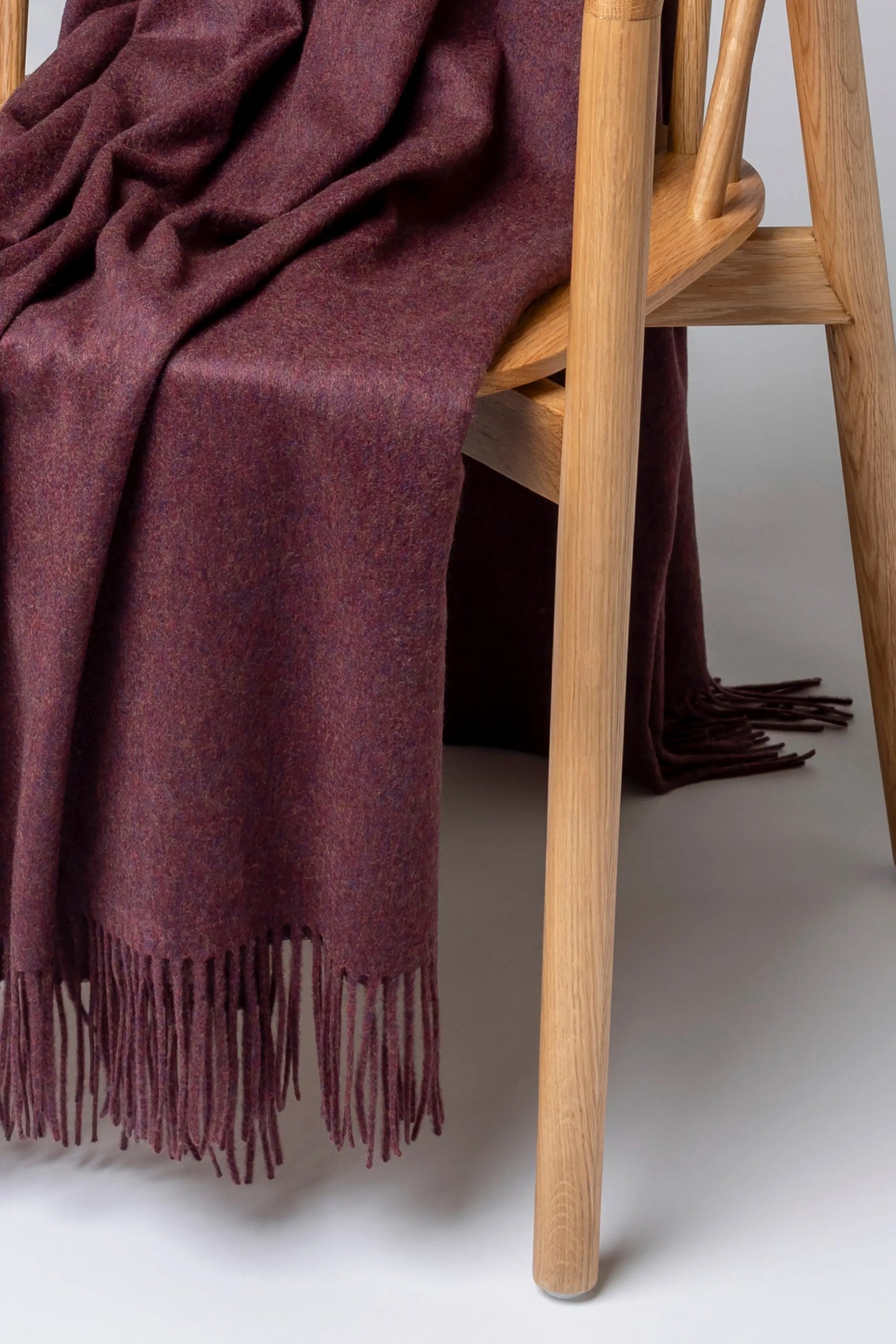 2025 Johnstons of Elgin Interiors Collection Damson Damson Cashmere Throw on a grey background WA000055HE7062ONE