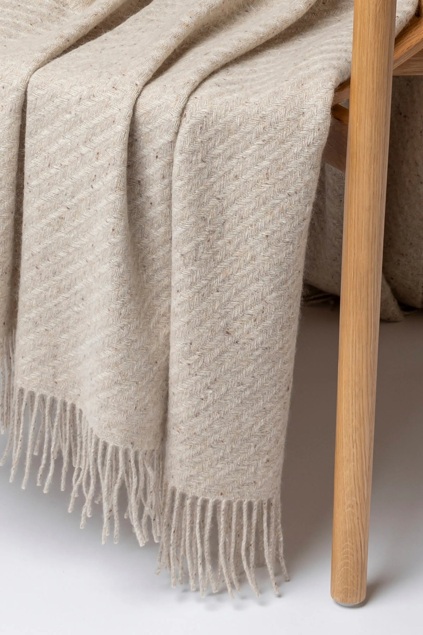 2025 Johnstons of Elgin Interiors Collection Cream Dun Lofty Twill Cashmere Throw on a grey background WAC02308RU7655ONE