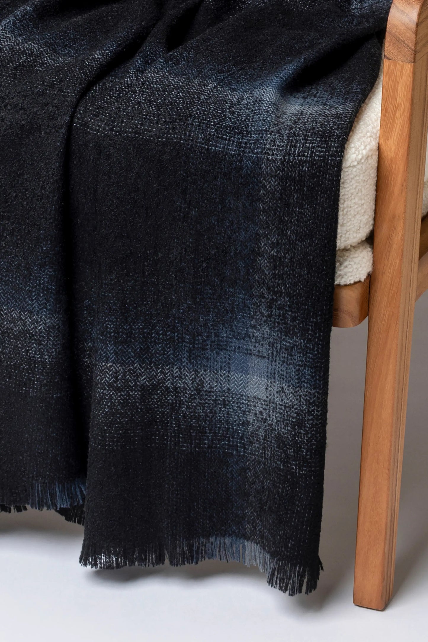 2025 Johnstons of Elgin Interiors Collection Black Blurred Bouclé Throw on a grey background WB002788RU7670ONE