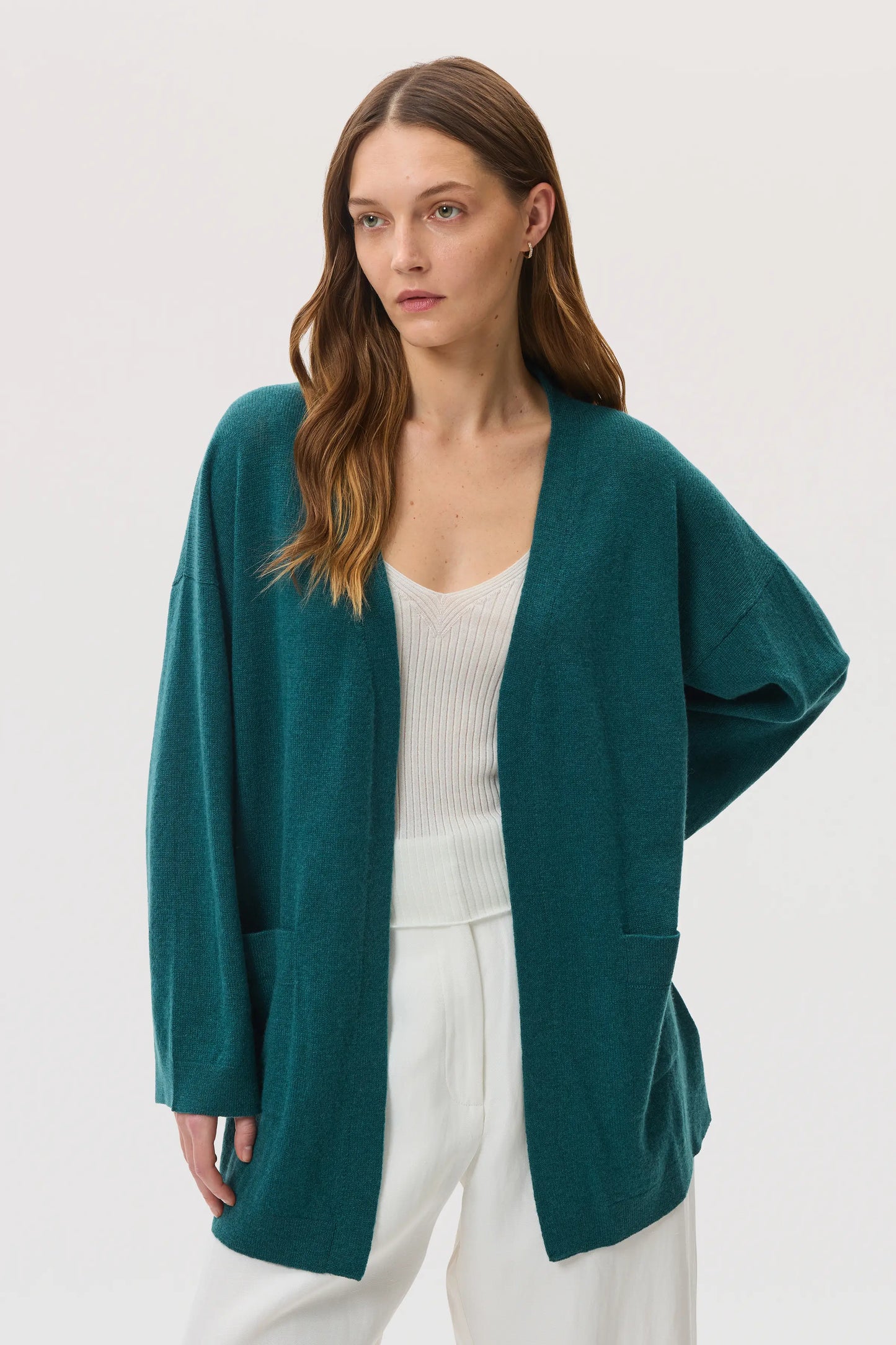 Model wearing Johnstons of Elgin SS25 Women's Knitwear Emerald Cashmere Kimono Cardigan with superfine cashmere vest in white on a white background KAI05446HA0327