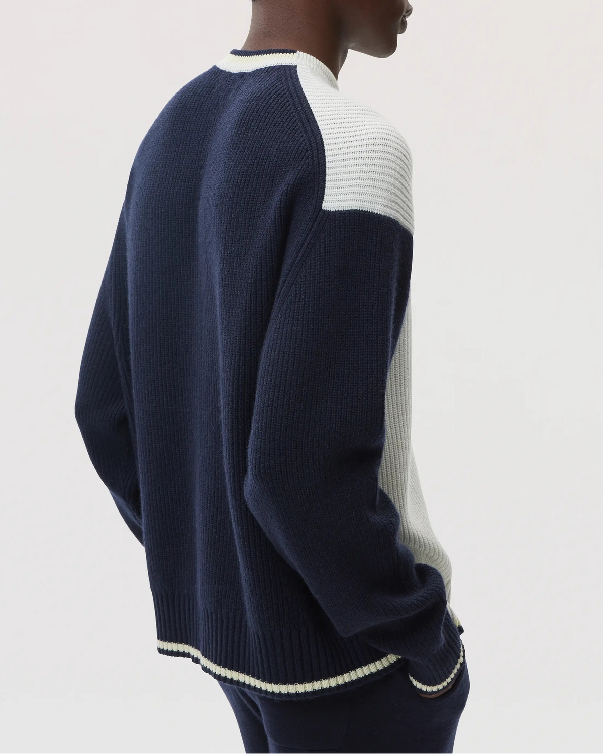 Model wears Johnstons of Elgin SS25 Men's Knitwear Navy & White Colour Block Relaxed Cashmere Jumper on a white background KAA05412Q25138