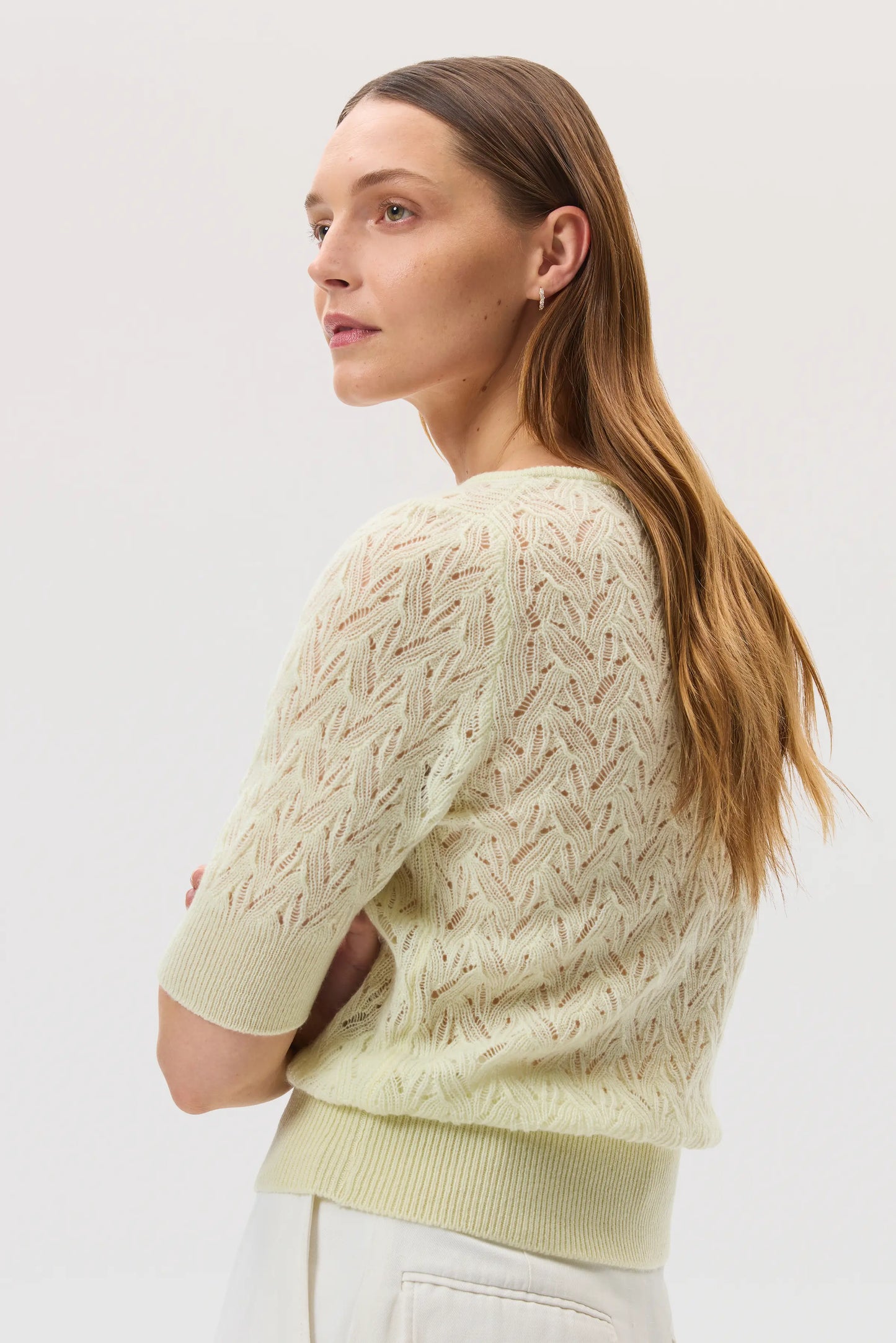 Johnstons of Elgin SS25 Women's Knitwear Lemon Feather Lace Cashmere Jumper with white trousers against a white backdrop KAA05428SA0145
