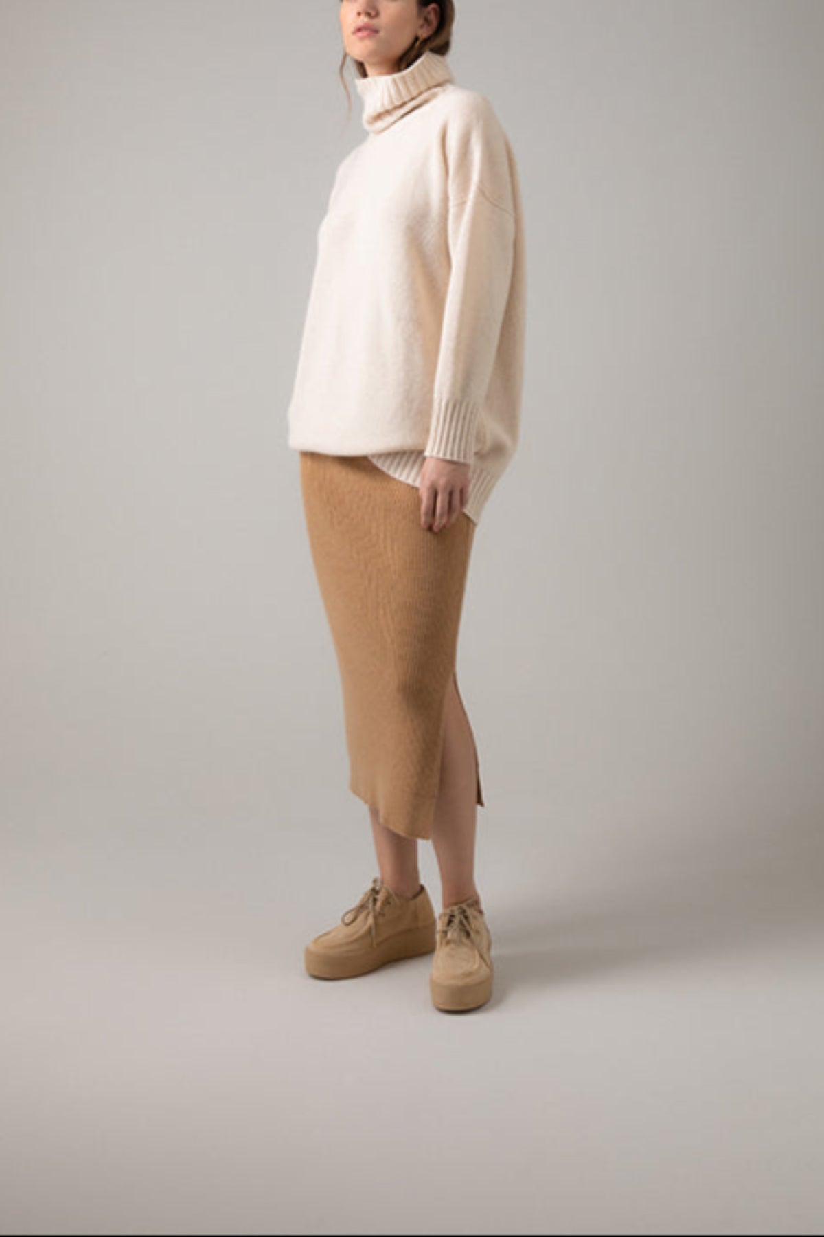 Johnstons of Elgin Ribbed Tube Cashmere Skirt in Camel worn with matching Slim Fit Cashmere Sweater on a grey background KBP00923HB4315