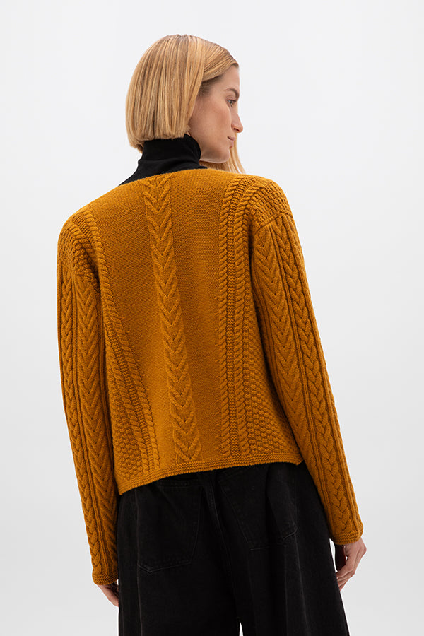 Person wearing a mustard yellow cable knit sweater on a white KAC05307SF4347