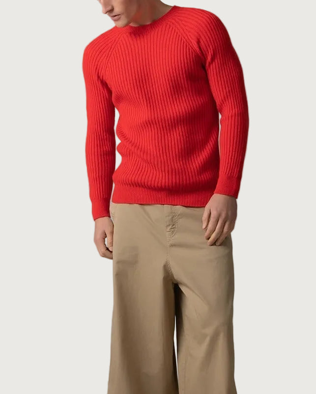 Johnstons of Elgin’s Men's Ribbed Cashmere Round Neck Jumper in Orkney Red on model wearing wide camel trousers on a grey background KAI05105SE0661