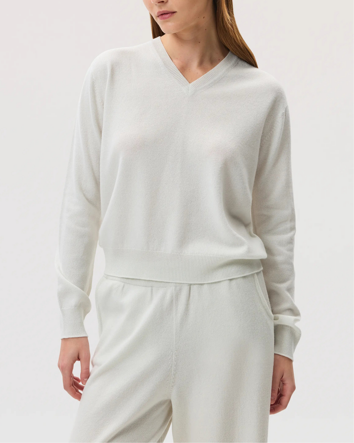 Model wearing Johnstons of Elgin SS25 Women's Knitwear White Classic Cashmere V Neck on a white background KAI05143HA0346