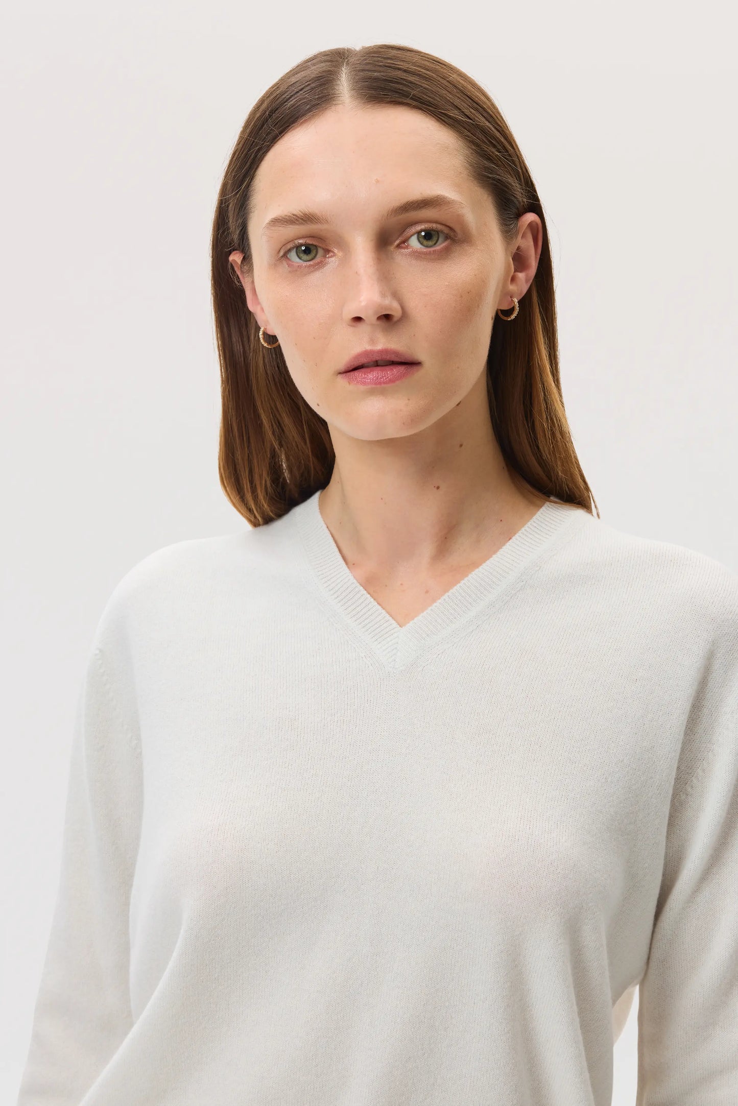 Model wearing Johnstons of Elgin SS25 Women's Knitwear White Classic Cashmere V Neck on a white background KAI05143HA0346