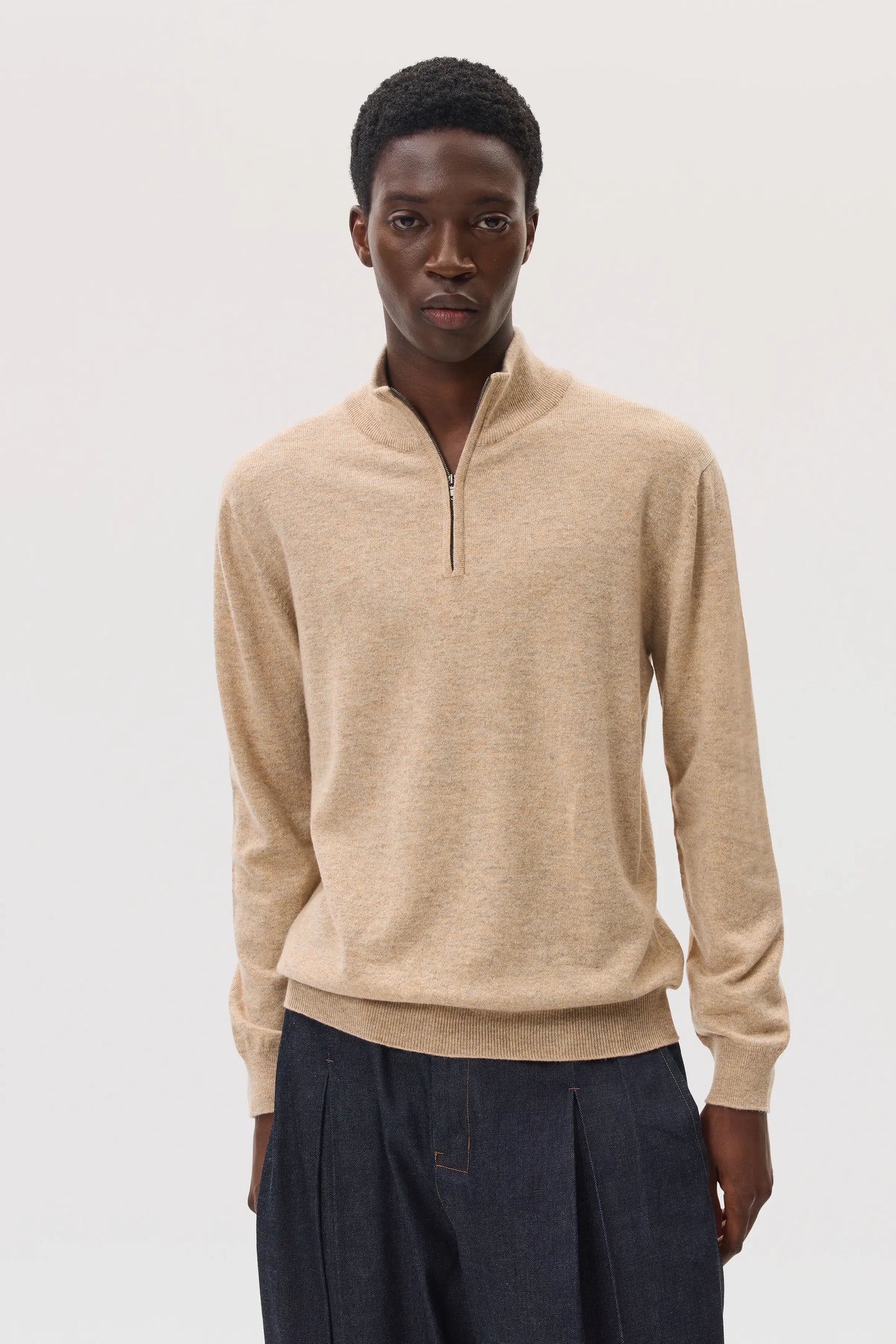 Model wearing Johnstons of Elgin SS25 Men's Knitwear Oatmeal Classic Cashmere Zip Neck on a white background KAI05151HB0210