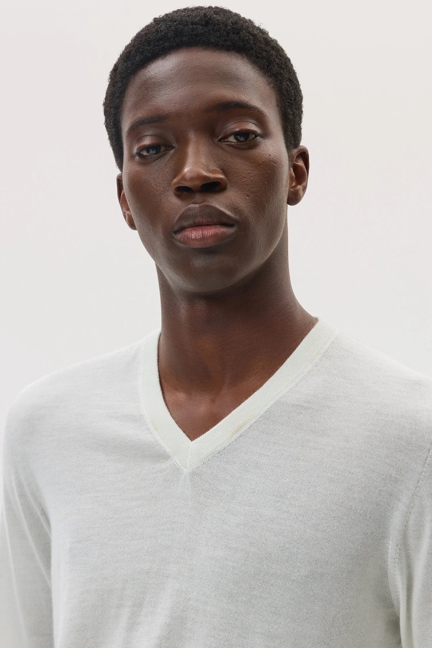 Male model wearing Johnstons of Elgin SS25 Unisex Knitwear White Superfine Cashmere V Neck KAI05242HA0327