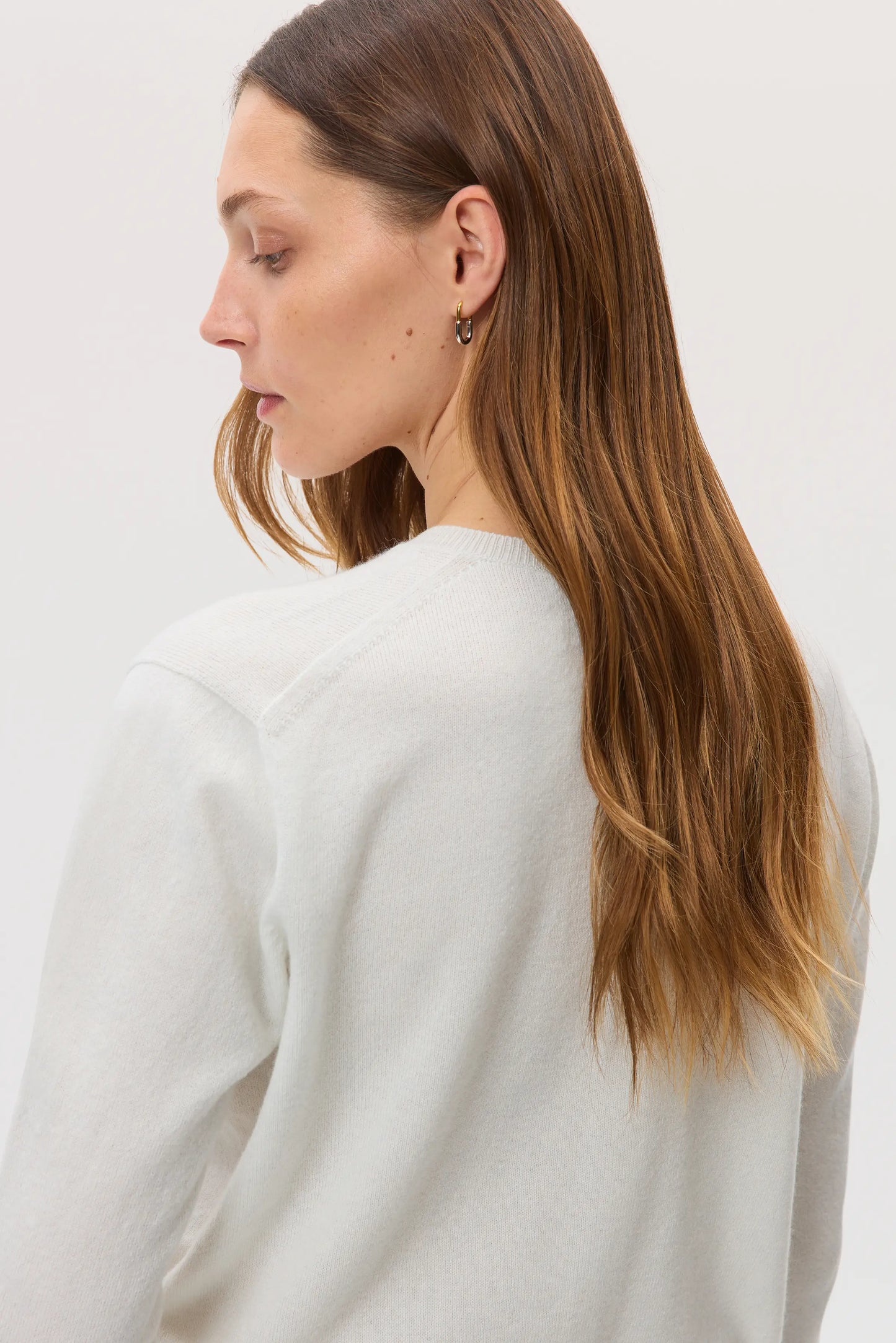 Model wearing Johnstons of Elgin SS25 Women's Knitwear White Classic Cashmere Cardigan on a white background KAI05274HA0346