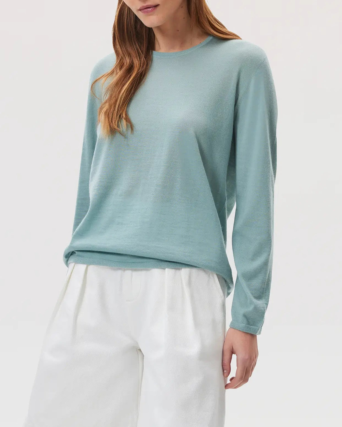 Model wearing Johnstons of Elgin SS25 Women's Knitwear Sage Superfine Cashmere Jumper with white shorts KAI05318SC0249