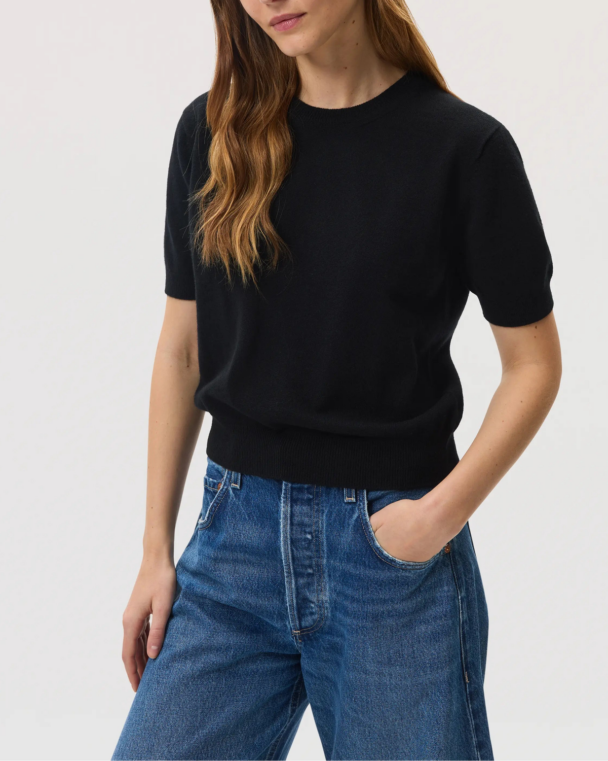 Model wears Johnstons of Elgin SS25 Women's Knitwear Black Classic Cashmere T-Shirt with blue barrel leg jeans KAI05371SA0900