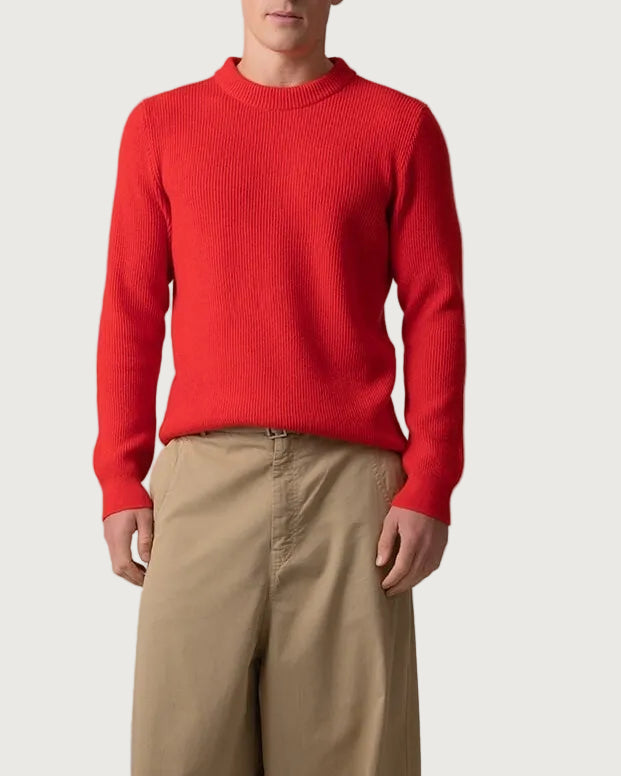 Johnstons of Elgin Men’s Ribbed Cashmere Round Neck Jumper in Orkney Red on model wearing camel trousers on grey background KAP05144SE0661