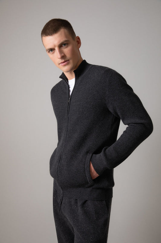 Johnstons of Elgin Men’s Ribbed Cashmere Zip Turtle Neck Cardigan in Charcoal on model wearing grey cashmere joggers on grey background KAP05157HA7165