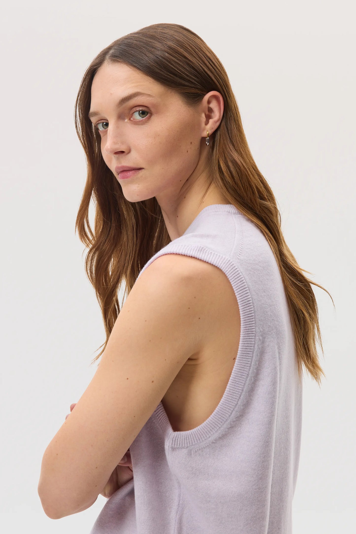 Female model wearing Johnstons of Elgin SS25 Unisex Knitwear Lavender Cashmere Tank against a white backdrop KAP05243HD0086