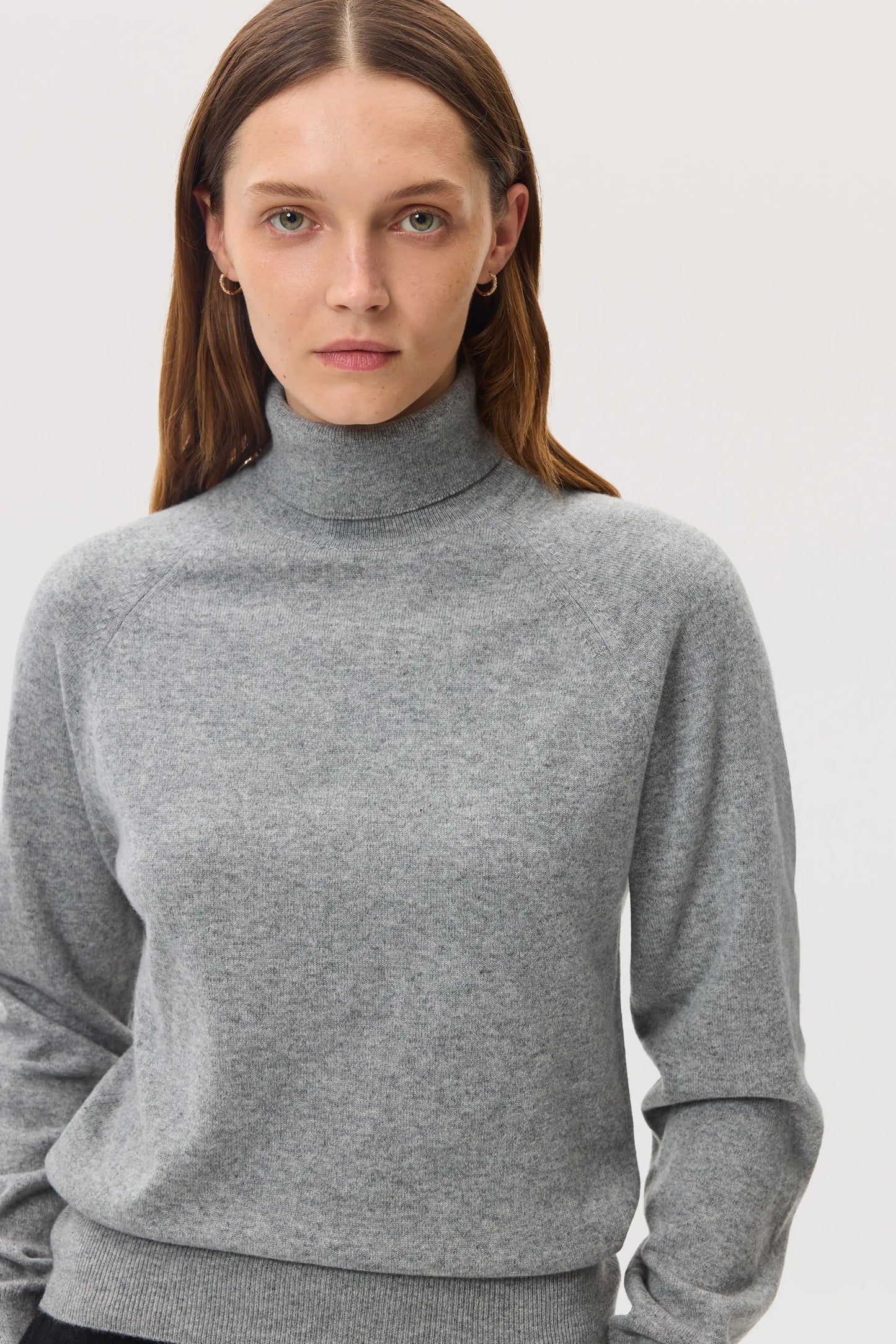 Model wears Johnstons of Elgin SS25 Women's Knitwear Light Grey Classic Cashmere Roll Neck Sweater on a white background KAP05275HA0308