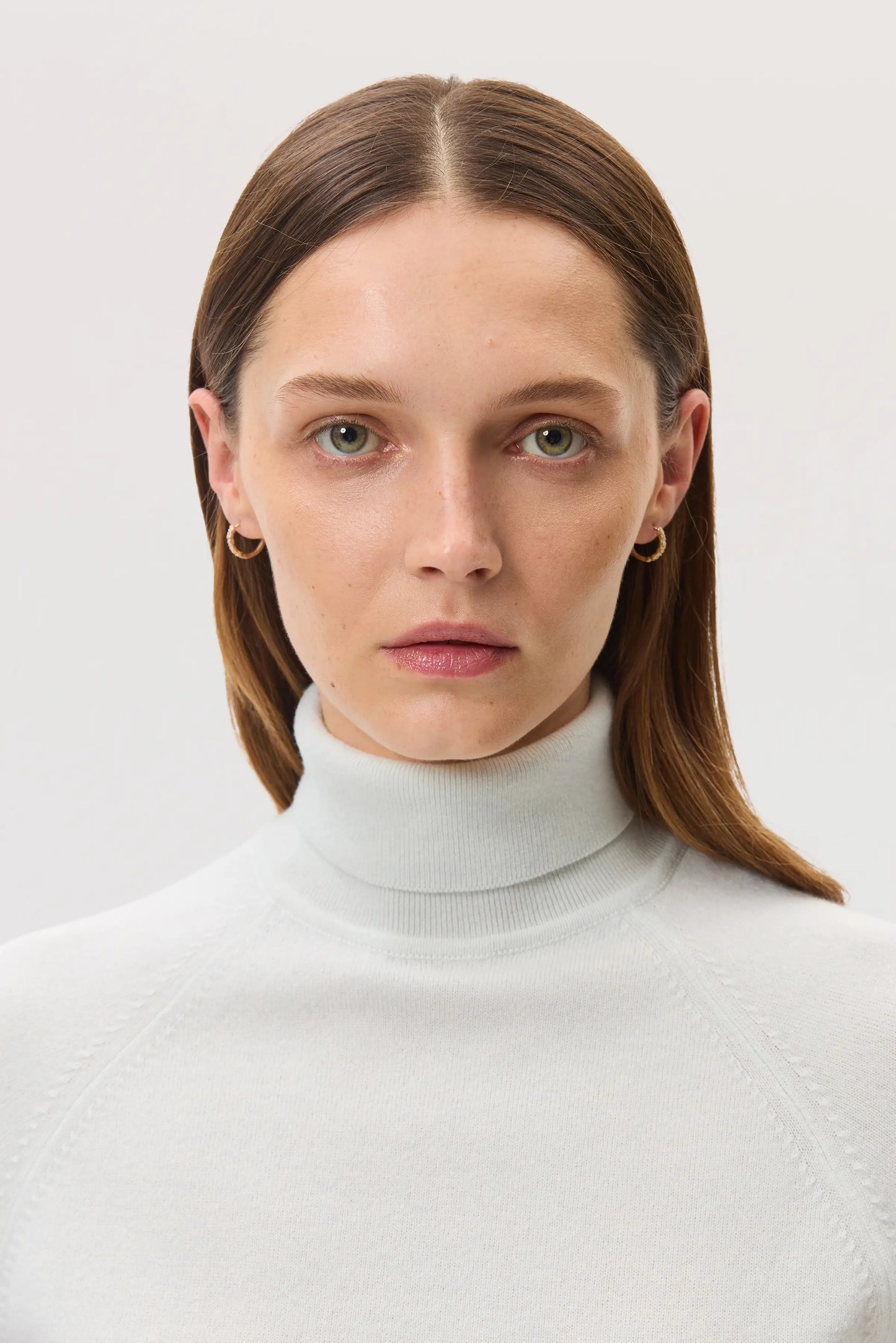 Model wears Johnstons of Elgin SS25 Women's Knitwear White Classic Cashmere Roll Neck Sweater KAP05275HA0346