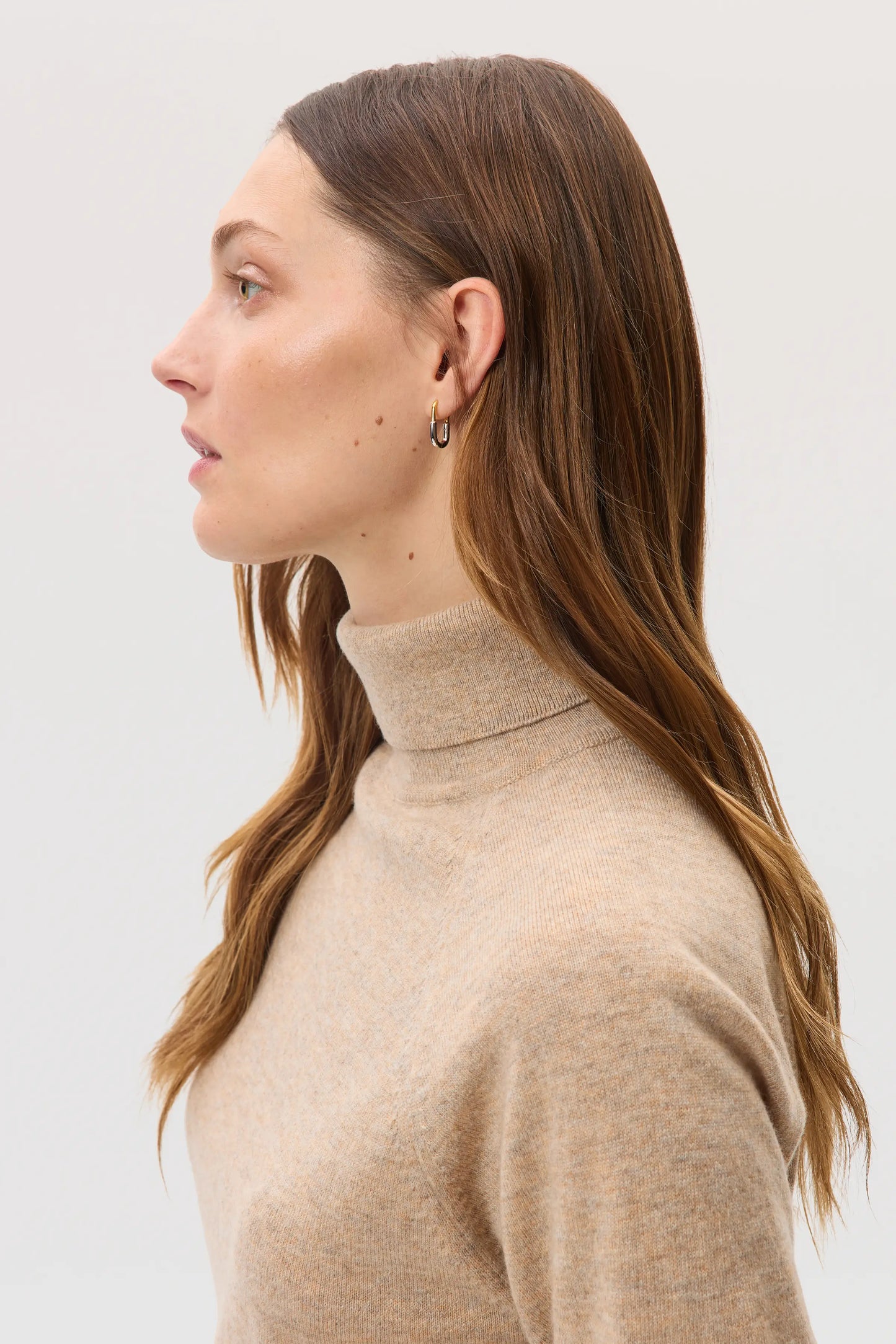 Model wears Johnstons of Elgin SS25 Women's Knitwear Oatmeal Classic Cashmere Roll Neck Jumper KAP05275HB0210