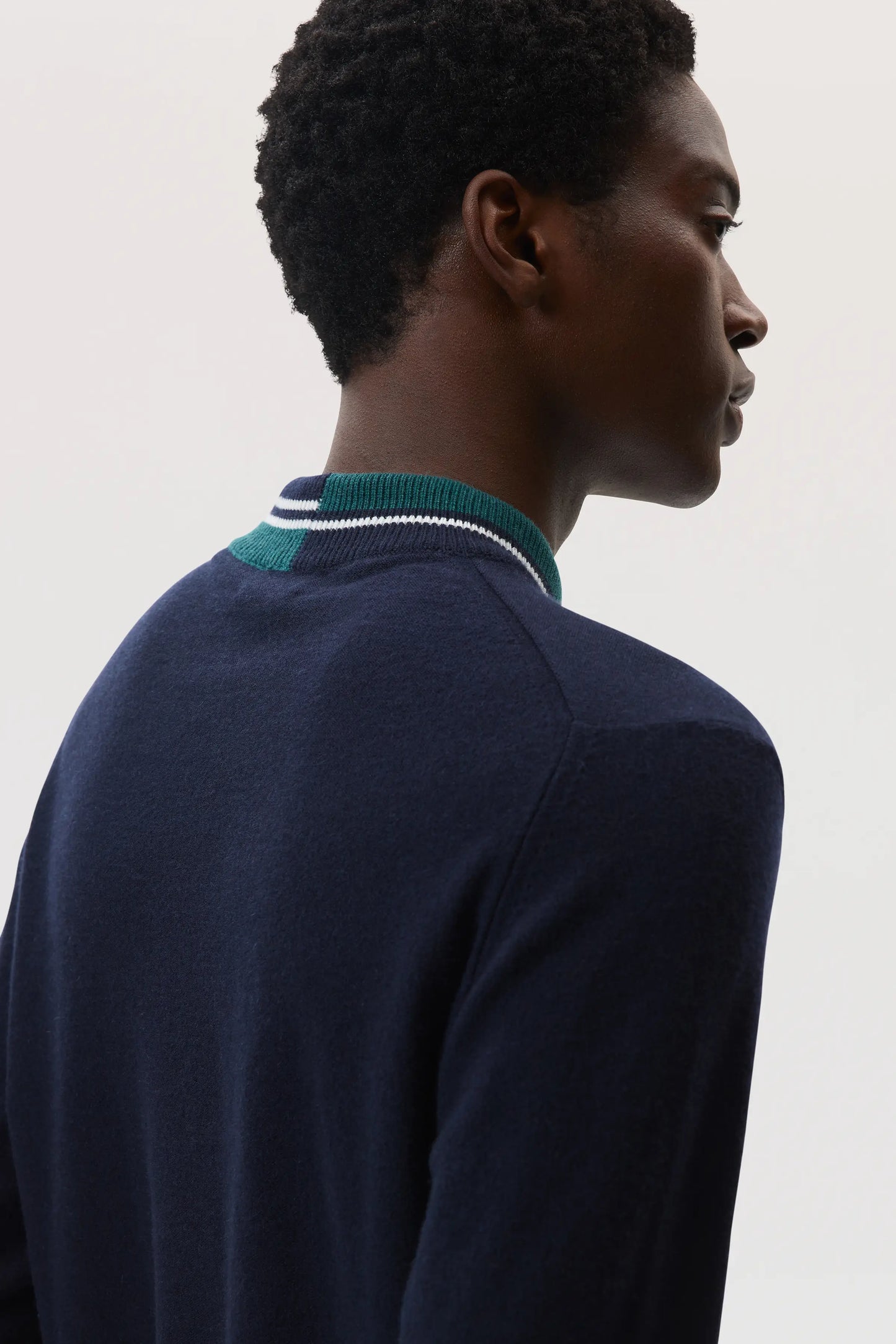 Johnstons of Elgin SS25 Men's Knitwear Navy Cashmere V Neck Sweater with Striped Trim in emerald on a white backdrop KAP05410Q25119