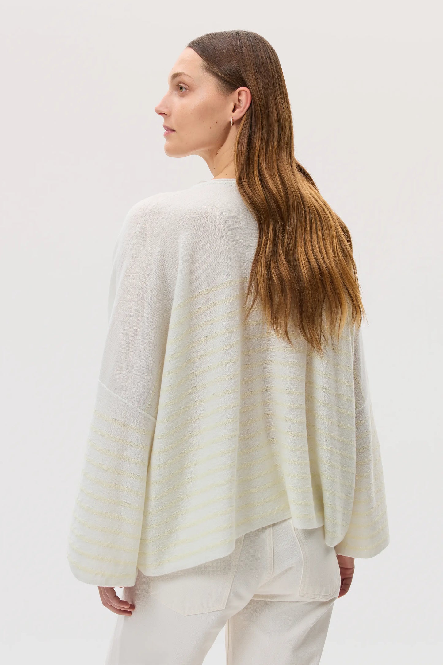 Model wearing Johnstons of Elgin SS25 Women's Knitwear White & Lemon Relaxed Featherlight Cashmere Stripe Jumper on a white backdrop KAP05425Q25139