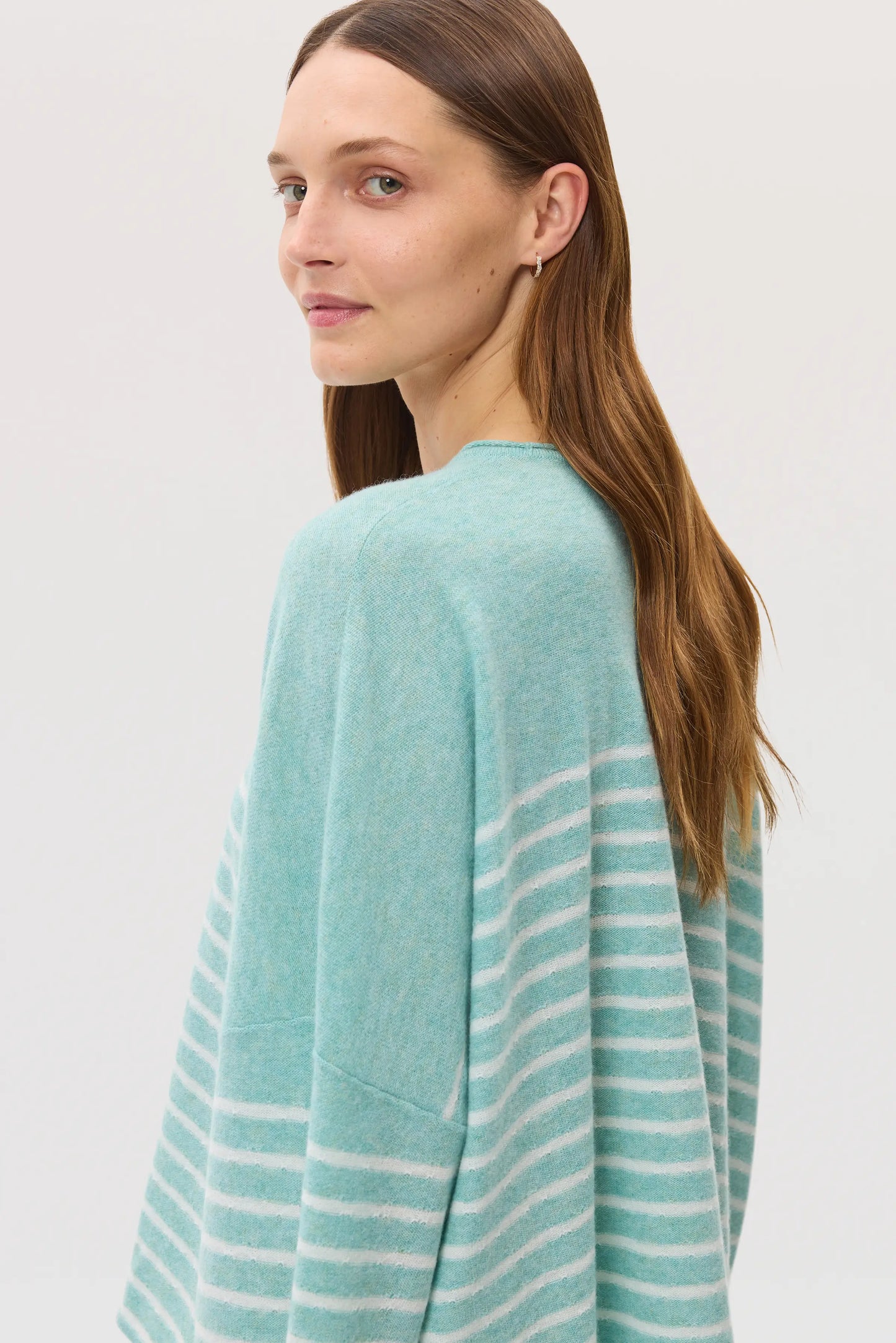 Model wearing Johnstons of Elgin SS25 Women's Knitwear Jade & White Relaxed Featherlight Cashmere Stripe Jumper in a studio setting KAP05425Q25141