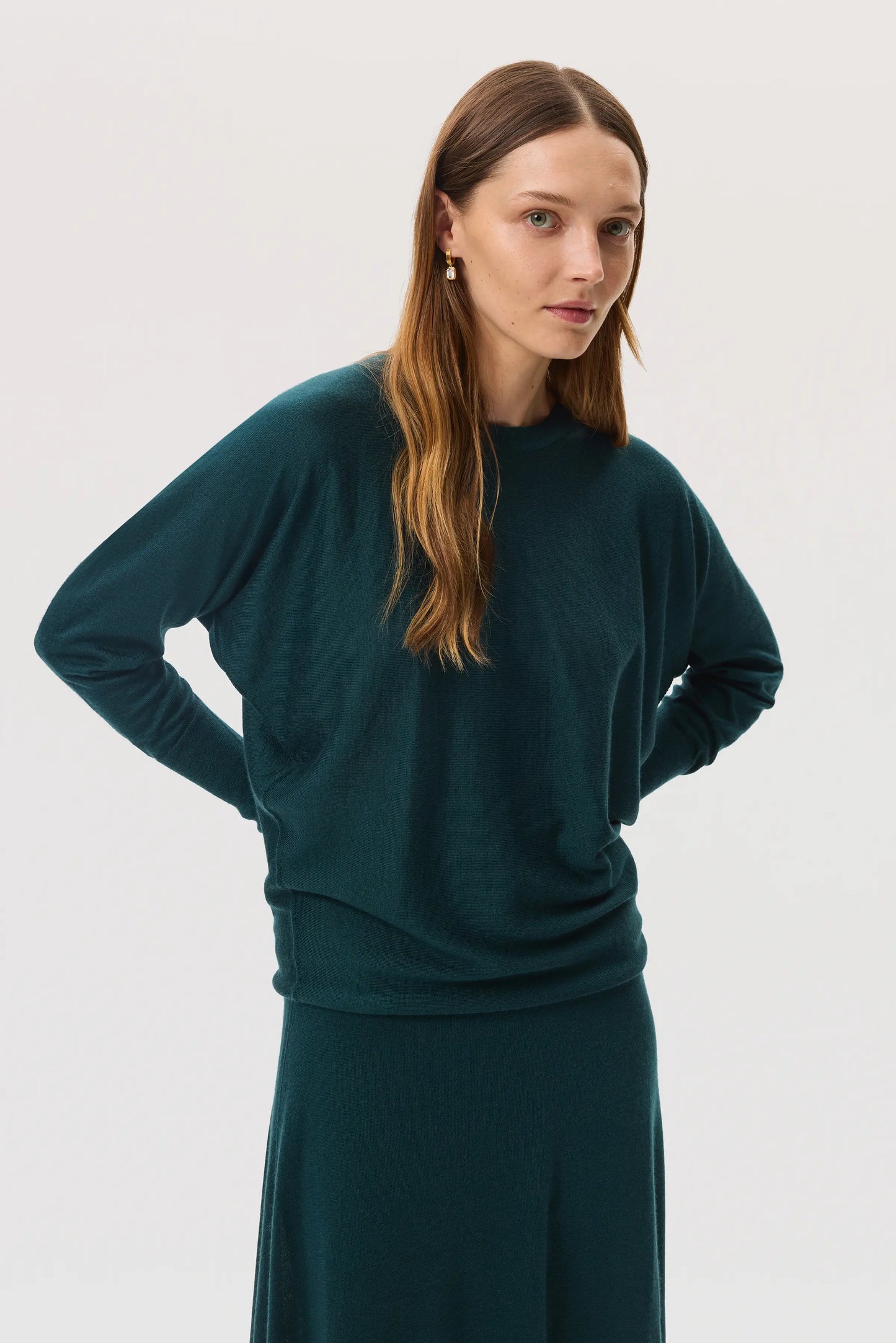 Model wears Johnstons of Elgin SS25 Women's Knitwear Emerald Cashmere Silk Batwing Sweater on a white background KBI00975SC7242