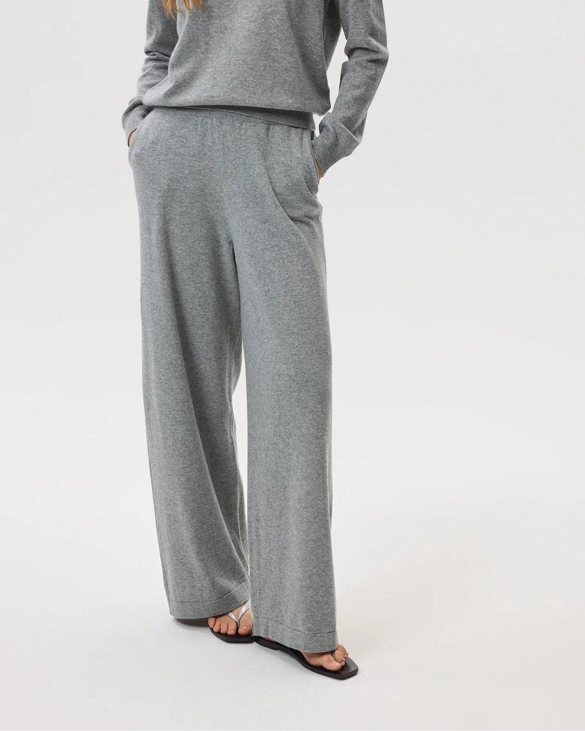 Model wearing Johnstons of Elgin SS25 Women's Knitwear Light Grey High Rise Cashmere Culottes with light grey cashmere crew neck sweater with black sandals KBP00926HA0200