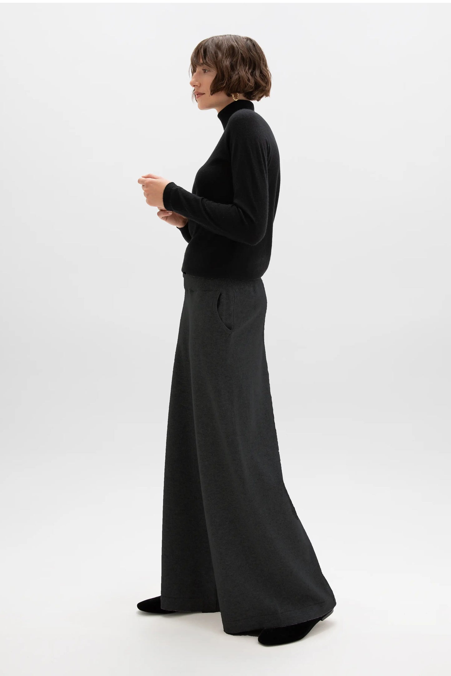 Model wearing Johnstons of Elgin Cashmere Slouch Trousers in Black with a matching Superfine Cashmere Roll Neck Sweater on a white background KBP00957SA7099