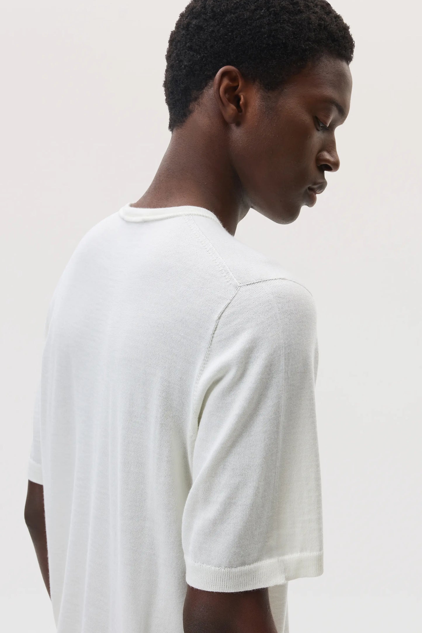 Model wears Johnstons of Elgin SS25 Men's Knitwear White Superfine Merino T-Shirt KDI00663SA0396