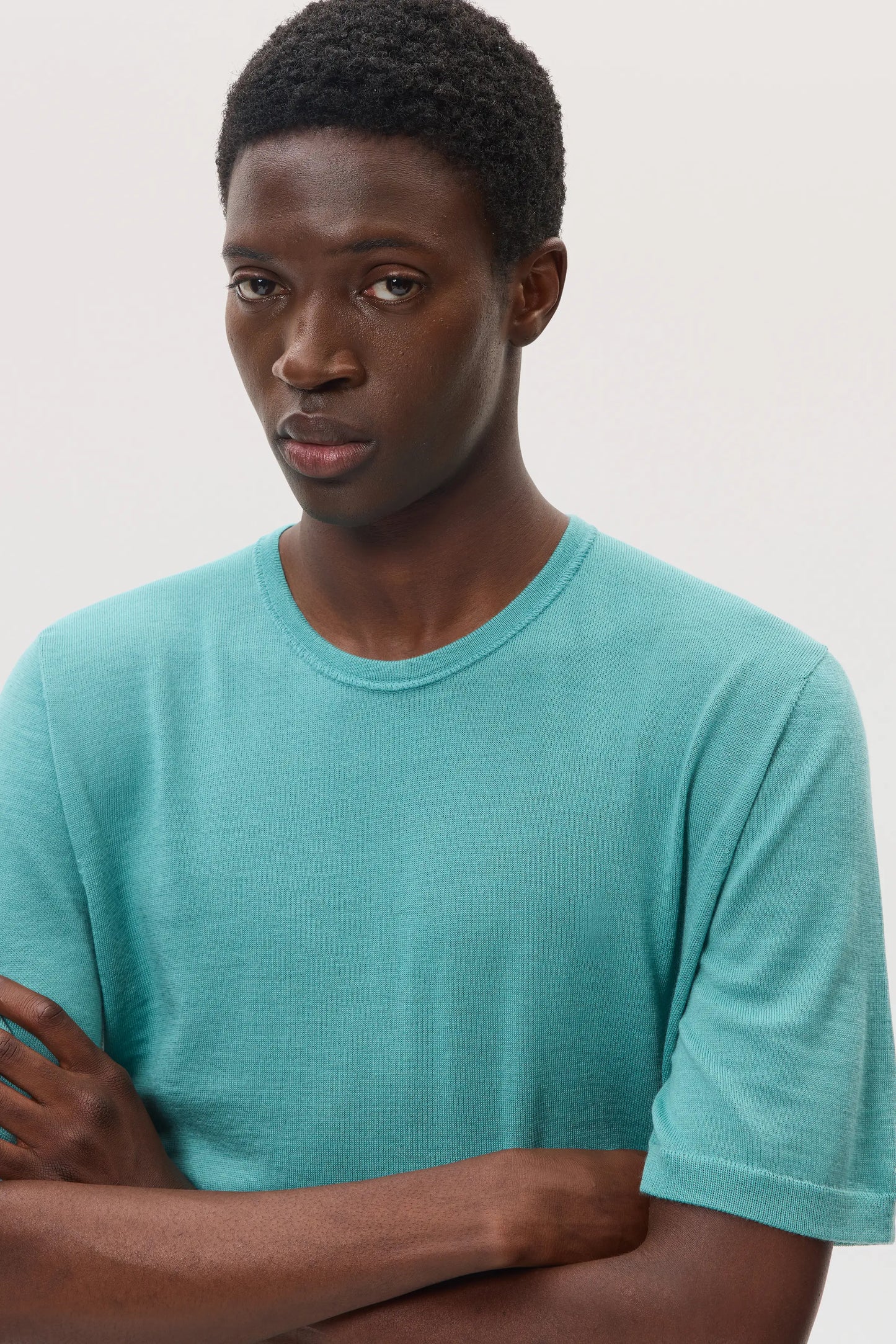 Model wearing Johnstons of Elgin SS25 Men's Knitwear Jade Superfine Merino T-Shirt against a white backdrop KDI00663SC4641