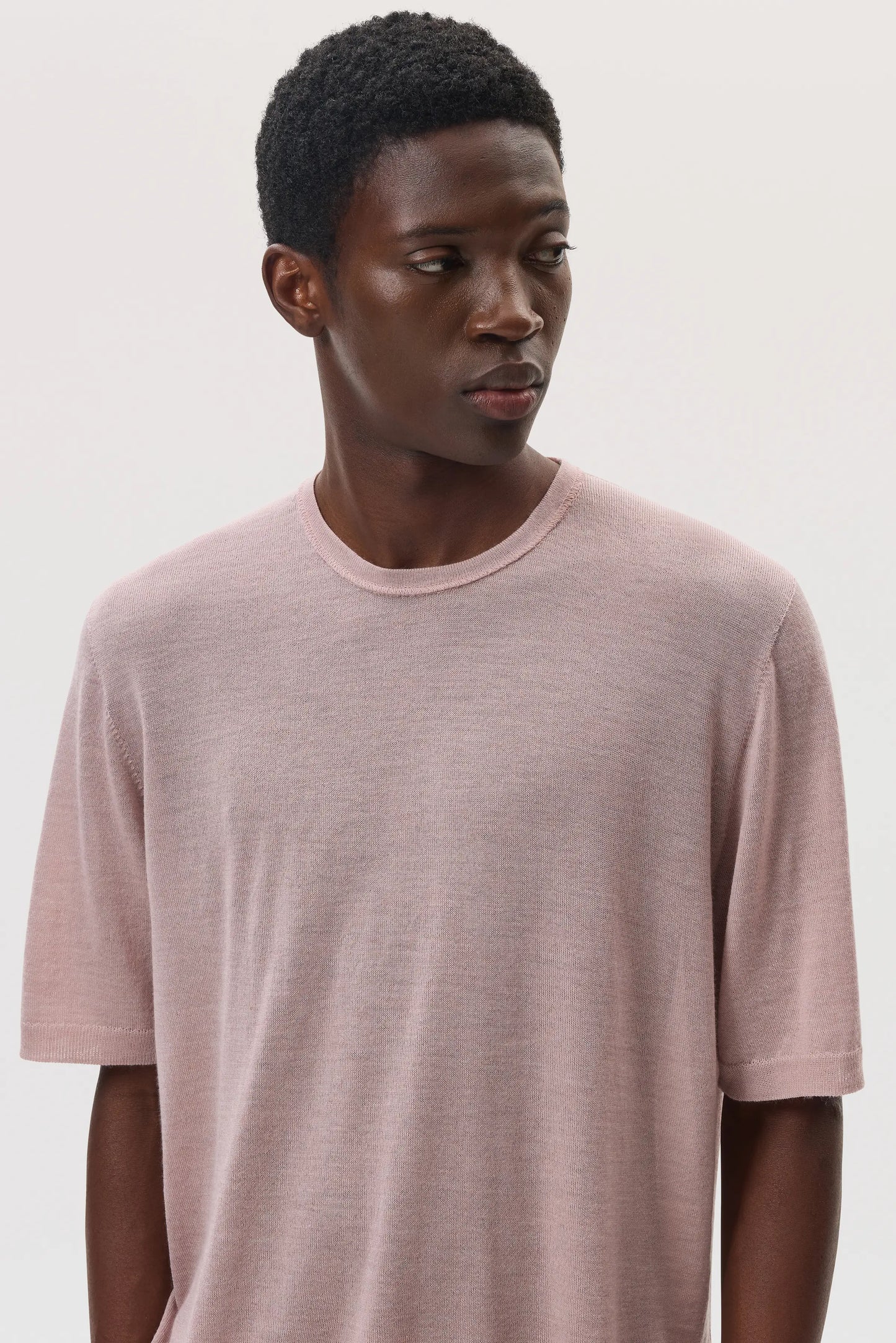 Model wearing Johnstons of Elgin SS25 Men's Knitwear Dusty Rose Superfine Merino T-Shirt against a white backdrop KDI00663SE5215