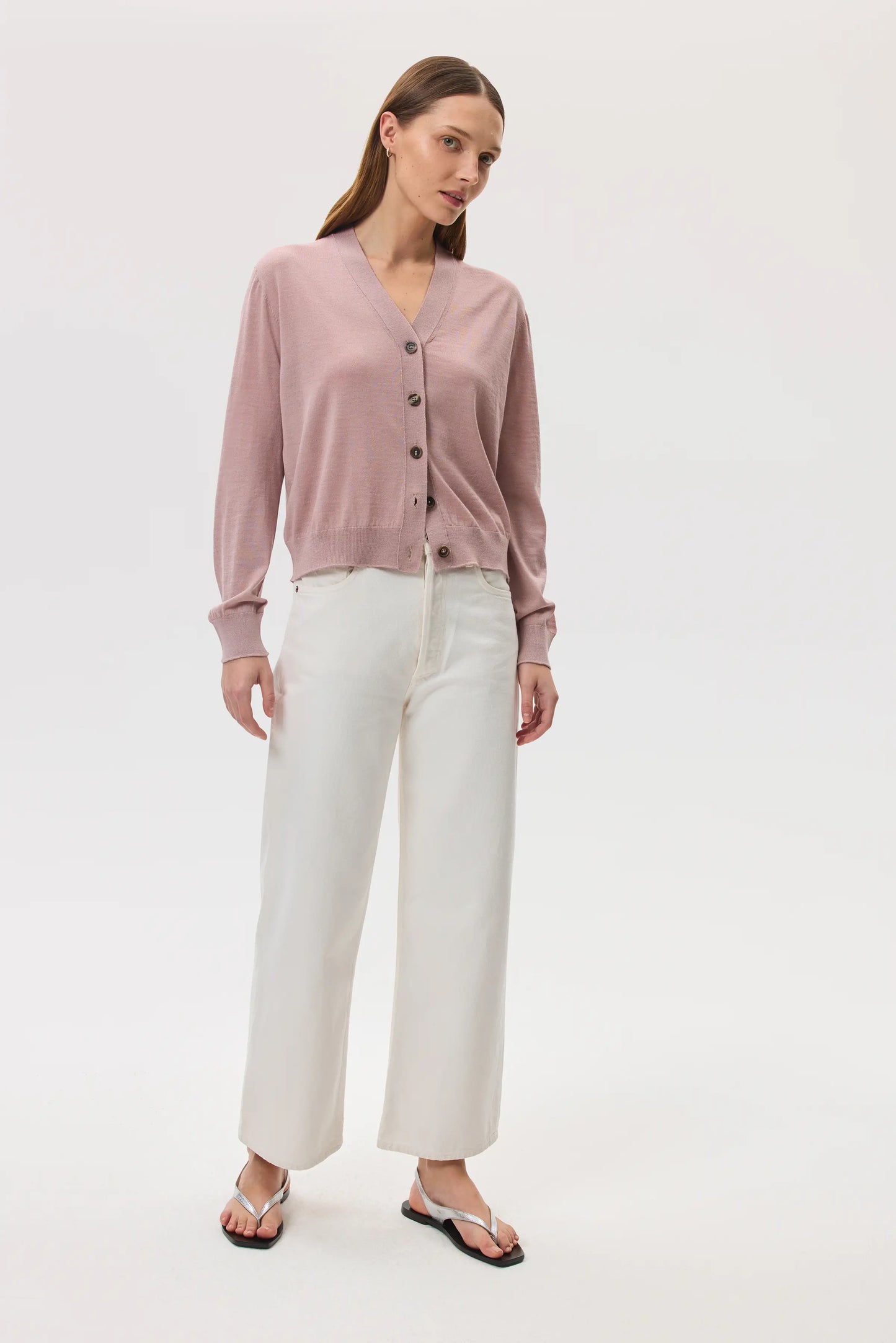 Model wears Johnstons of Elgin SS25 Women's Knitwear Dusty Rose Superfine Merino Wool Cardigan with white jeans on a white background
KDI00686SE5215