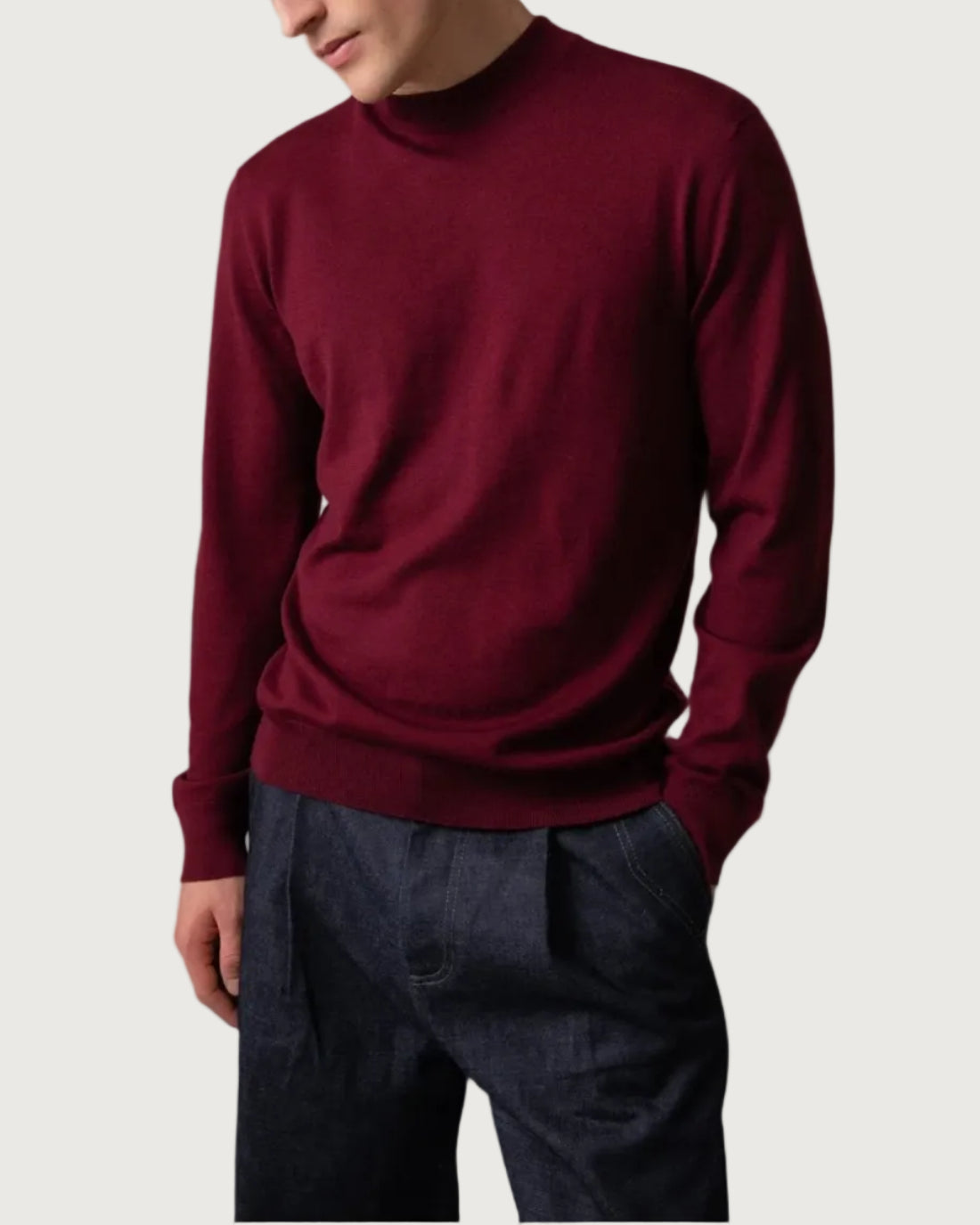 Johnstons of Elgin Men’s Merino Mock Turtleneck Jumper in Wine on model wearing navy trousers on grey background KDI00705SB7227