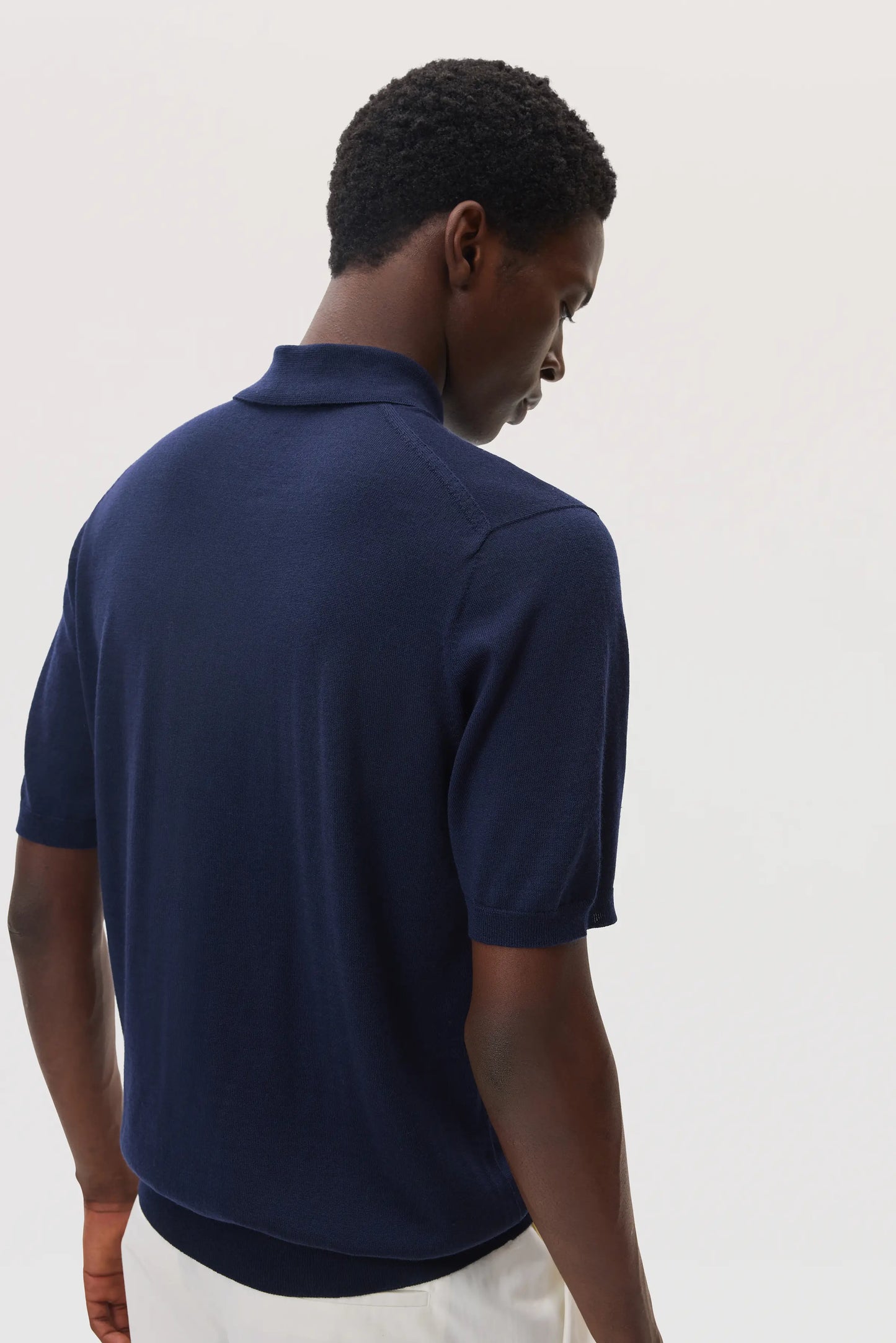 model wearing Johnstons of Elgin SS25 Men's Knitwear Navy Superfine Merino Polo Shirt KDI00715SD7563