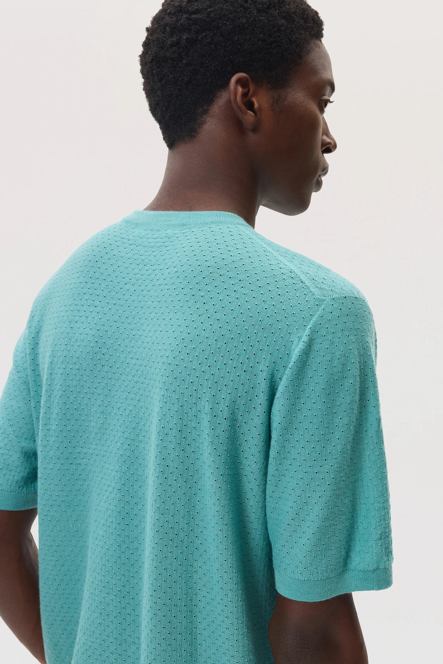 Model wearing Johnstons of Elgin SS25 Men's Knitwear Jade Superfine Merino Mesh T-Shirt KDI00730SC4641