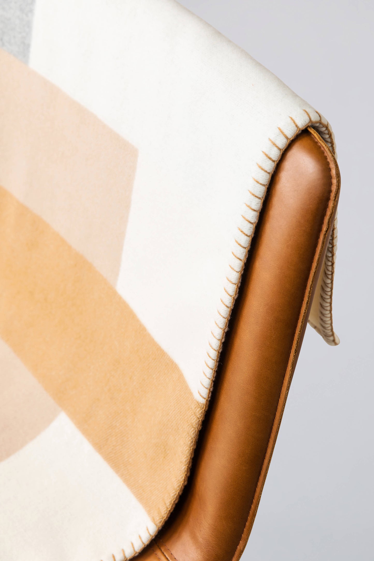 Johnstons of Elgin Grey & Natural Kids Pyramid Blanket Stitch Throw on a Leather Chair TB000582RU7279ONE