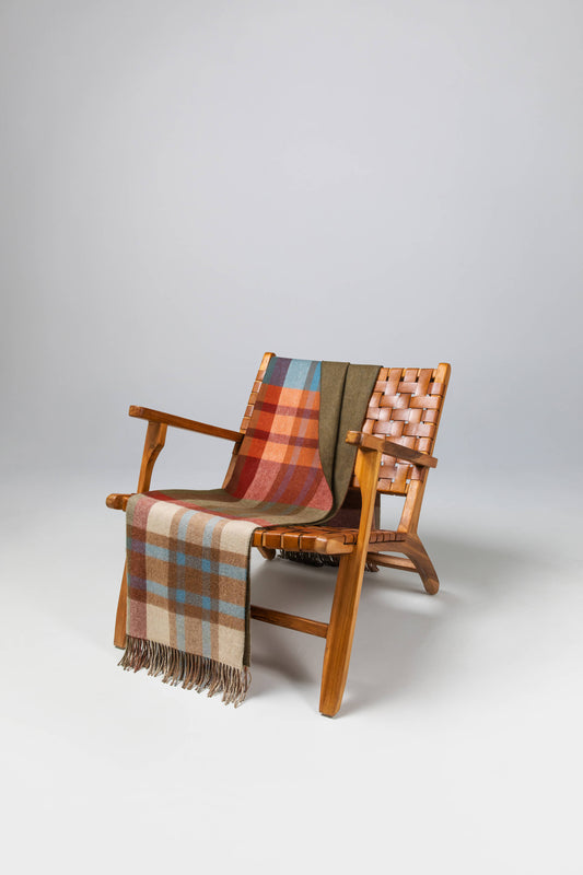 Johnstons of Elgin’s Deveron Check Reversible Cashmere Throw on brown chair on a grey background WA000013RU7286