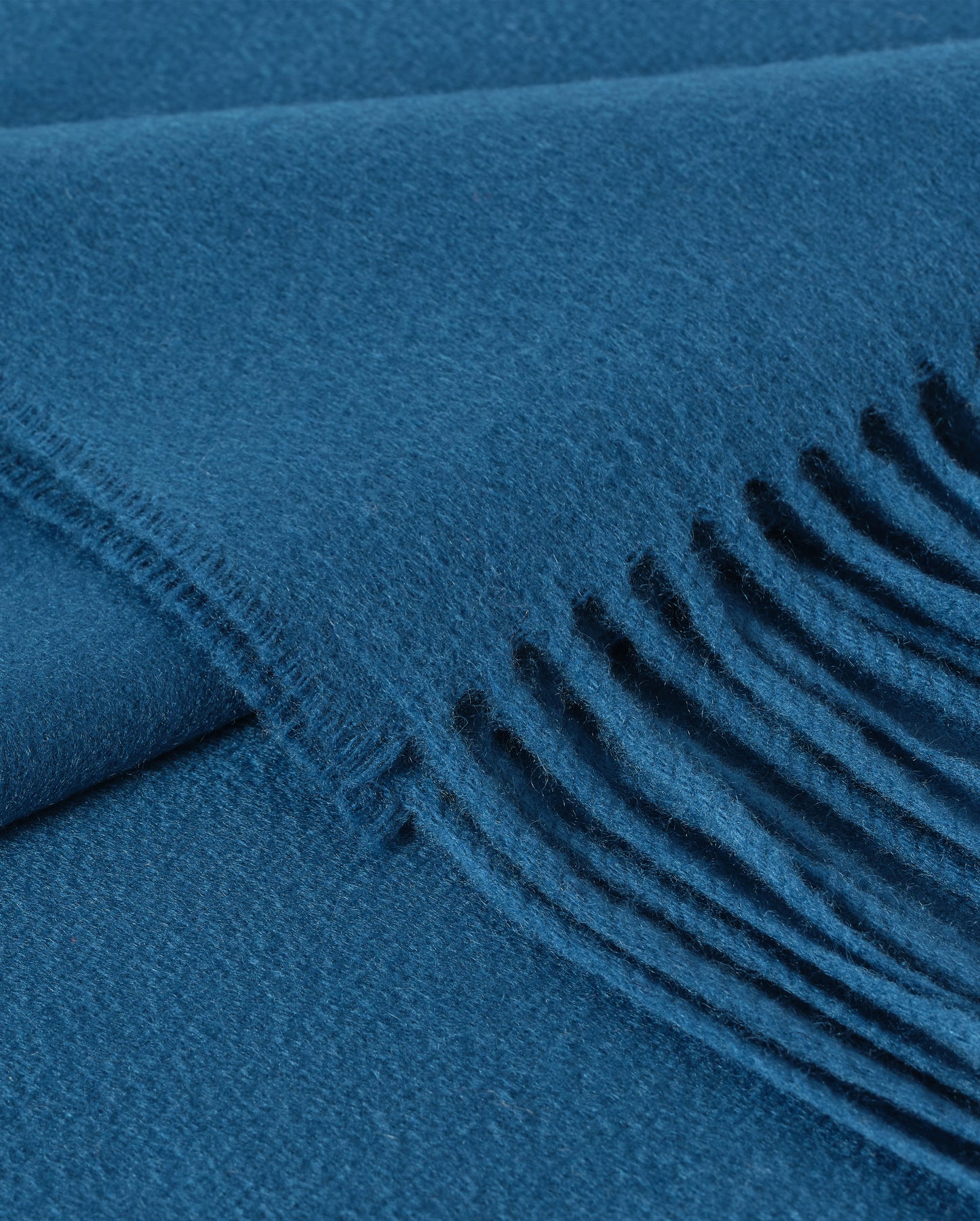 Johnstons of Elgin Plain Cashmere Throw in Petrol – luxury Scottish-woven cashmere throw in a rich petrol blue shade. WA000055SD5123ONE