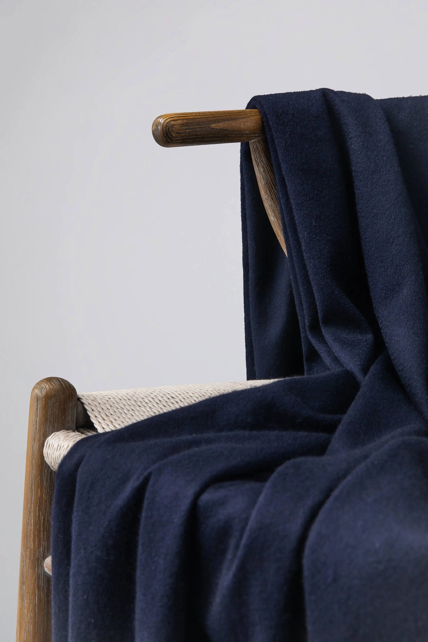 2025 Johnstons of Elgin Interiors Collection Dark Navy Cashmere Throw on a grey background WA000055SD7330ONE
