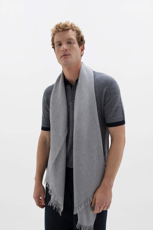 Johnstons of Elgin Lightweight Merino Wool Scarf in Silver grey worn by a male model over a navy merino wool t-shirt with navy trousers against a white background WD001093HA2051ONE