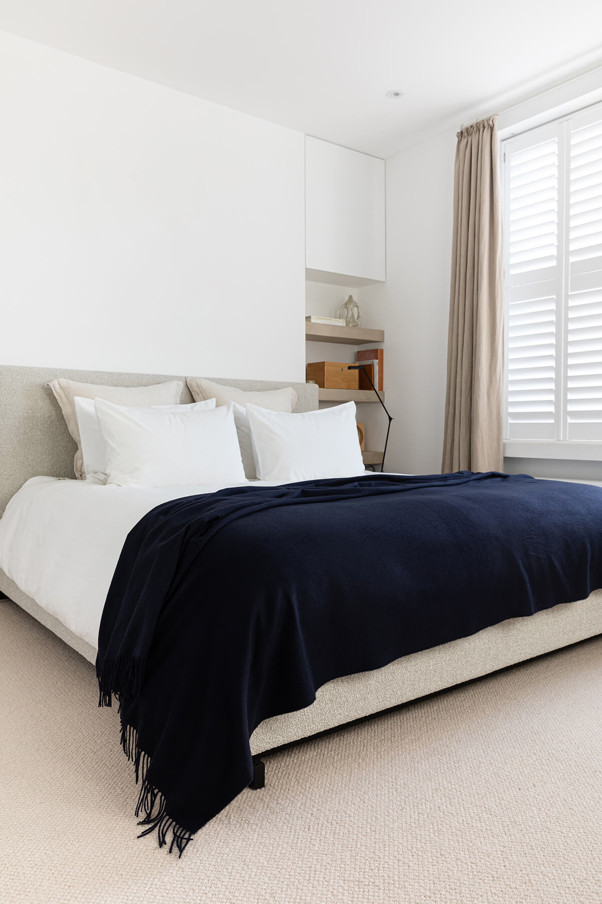 Johnstons of Elgin’s Cashmere Bed Throw in Navy on bed in neutral bedroom WA001159SD7330ONE