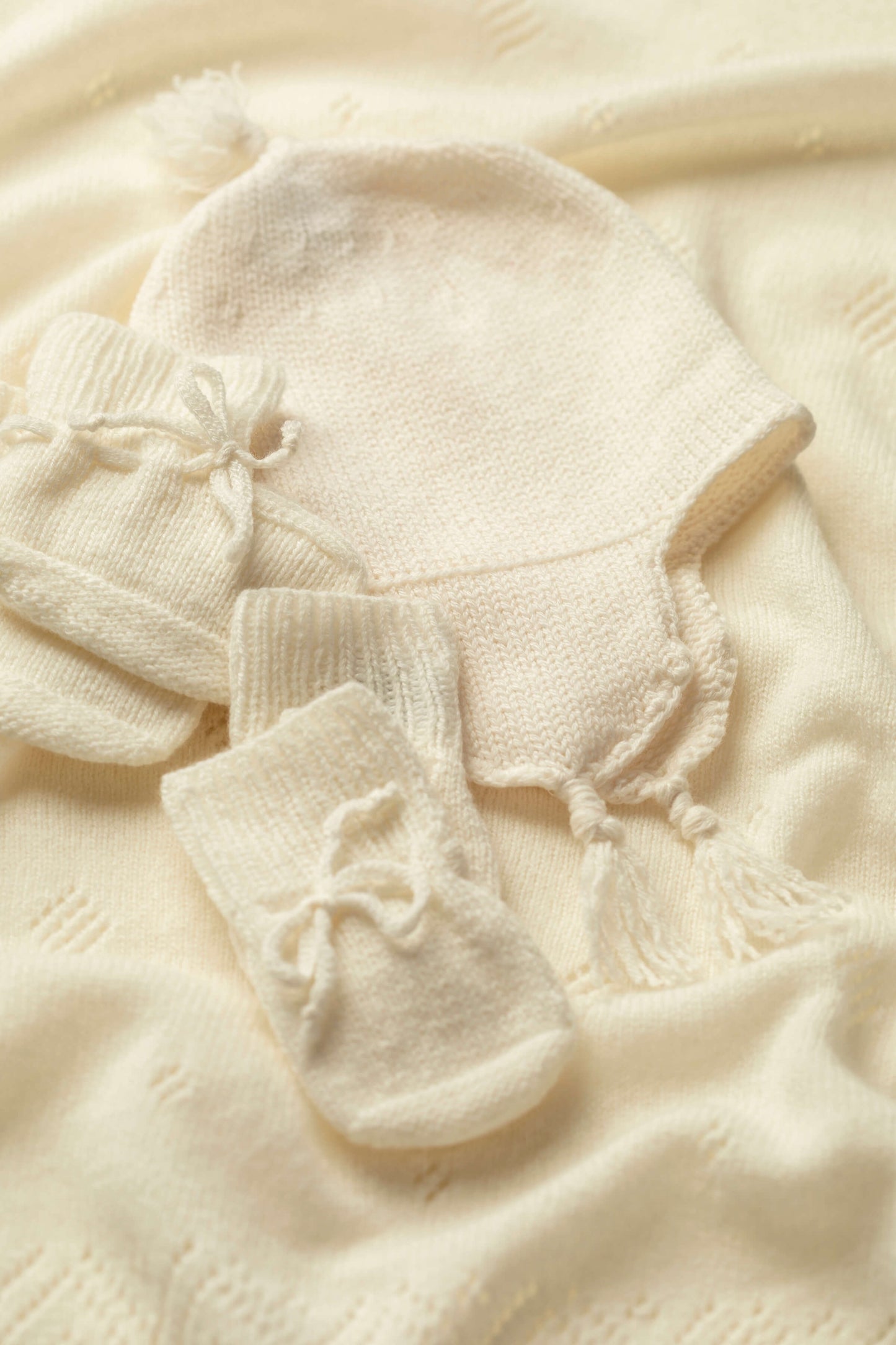 Johnstons of Elgin’s Gift Set includes our Cashmere Pointelle Baby Blanket, Hat, Mittens & Booties in Ecru on a white background AW21GIFTSET18A