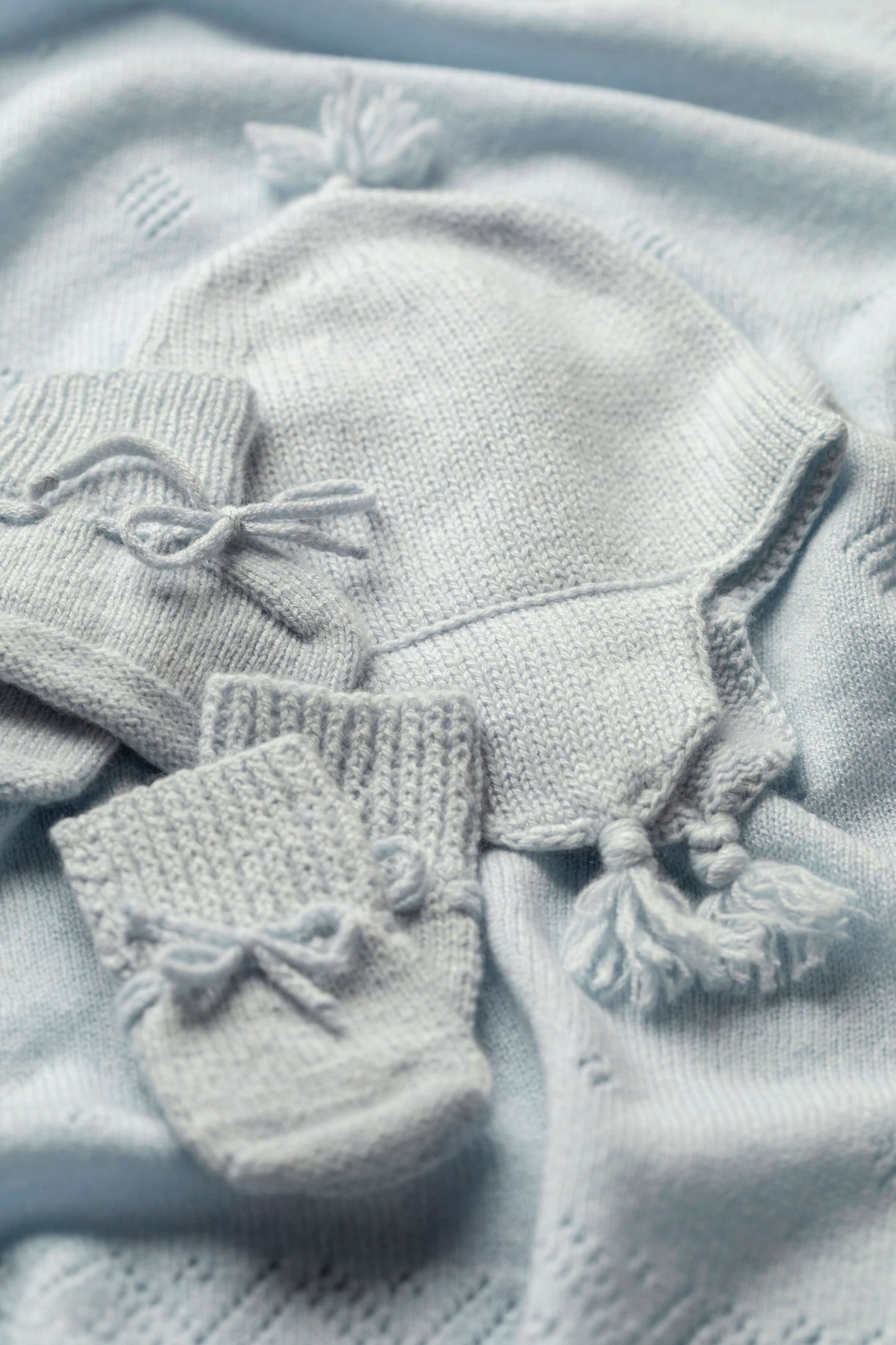 Johnstons of Elgin’s Gift Set includes our Cashmere Pointelle Baby Blanket, Hat, Mittens & Booties in Powder Blue AW21GIFTSET18C