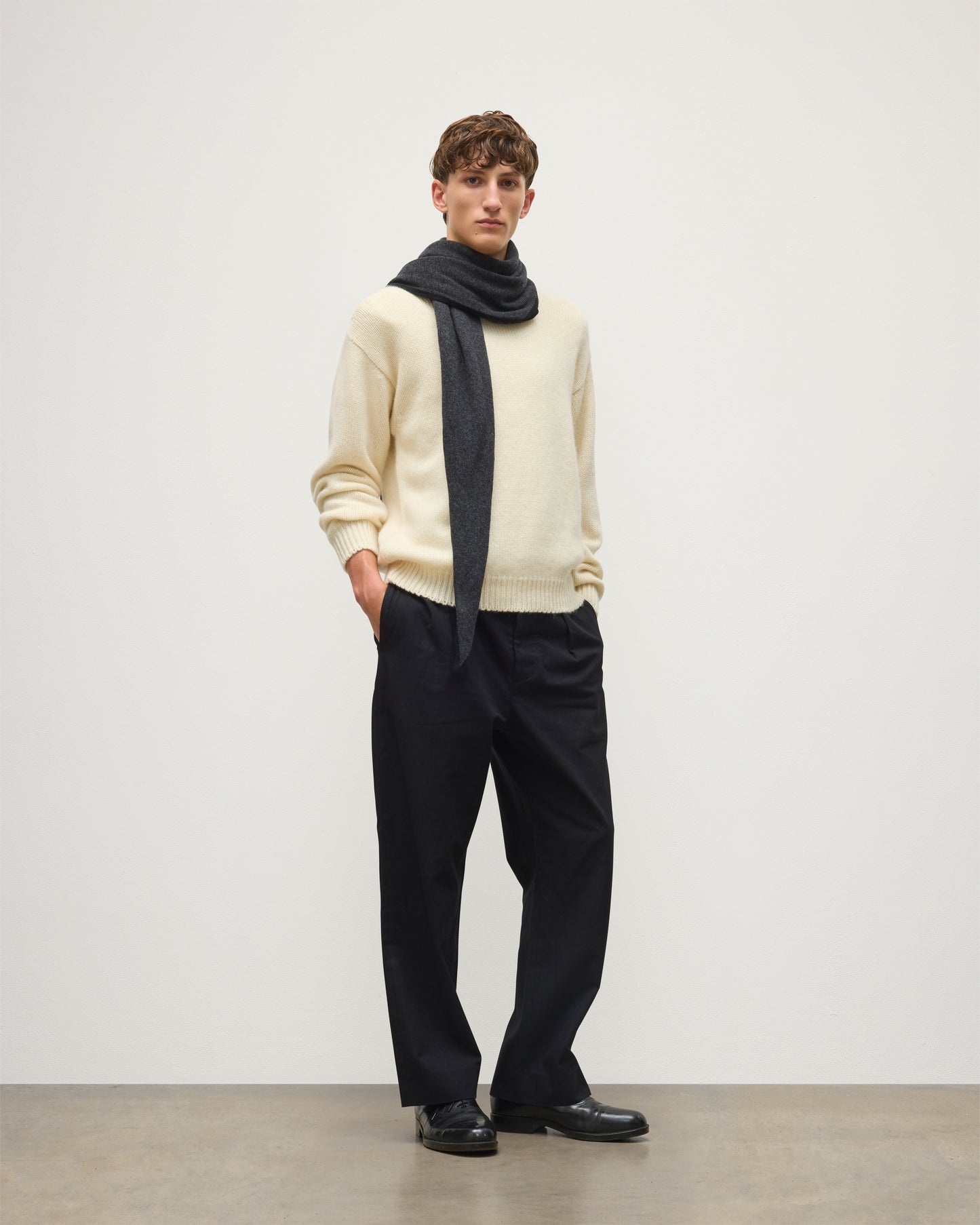 MALE MODEL WEARING JOHNSTONS OF ELGIN CASHMERE GAUZY ETHEL DIAMOND SCARF BLACK & GREY 100% CASHMERE OVER CREAM CASHMERE SWEATER HAE03401Q26237ONE