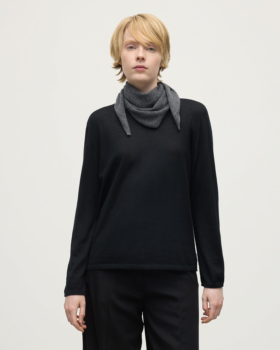 Model wearing Johnstons of Elgin AW25 Knitted Accessories  Gauzy Cashmere Grey Triangle Neck Tie with black cashmere sweater HAE03430HA4181ONE